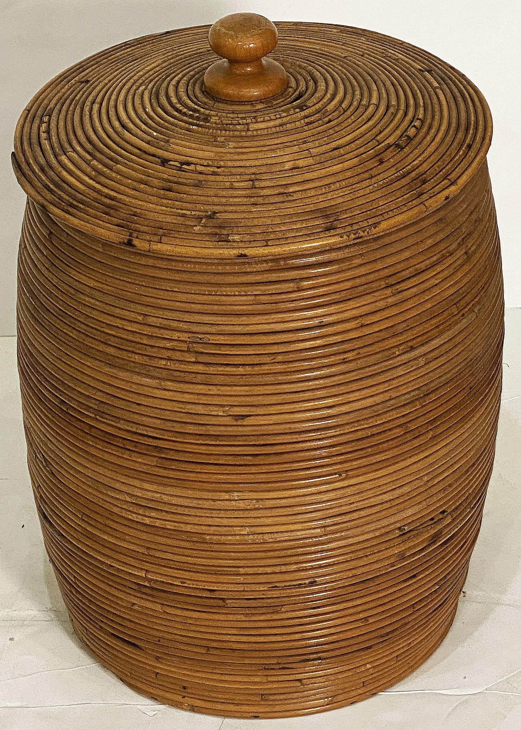A fine large French basket container featuring a removable round top lid with wooden finial set upon a cylindrical body of hand-woven spiral cane work.

Dimensions are H 22 3/4 inches by Diameter 15 3/4 inches

 