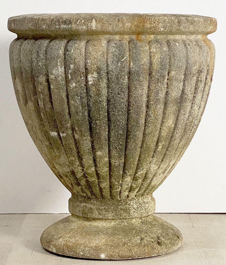 A large French round garden planter pot or urn featuring a shaped lip over a lobed body and raised circular base, (H 21 3/4 x Dia 19 1/4)

The diameter of the base is 13 1/2 inches.
