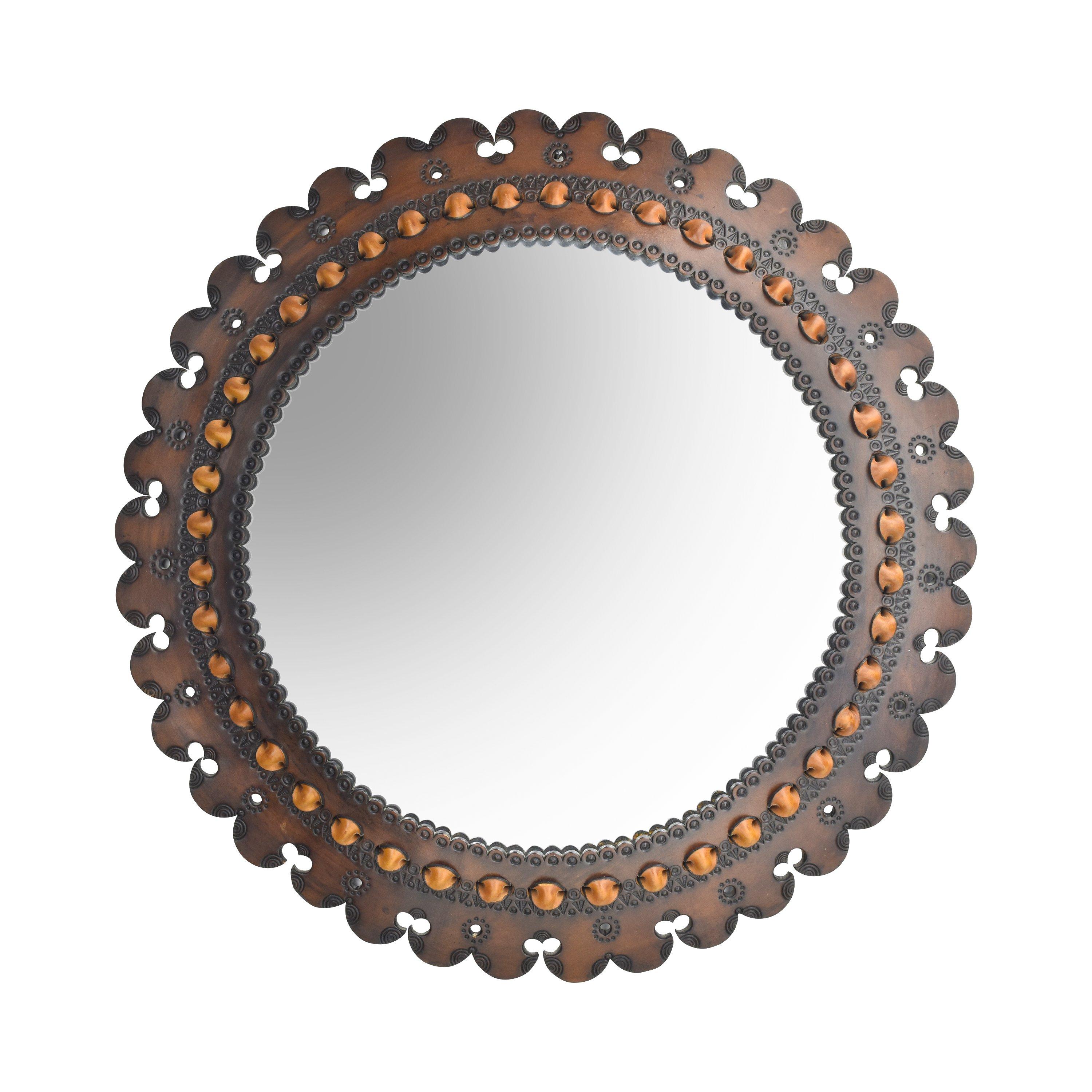 A large round handmade saddle leather wall mirror with embossed decorations and leather stitching dating to the 1960s probably made in France.