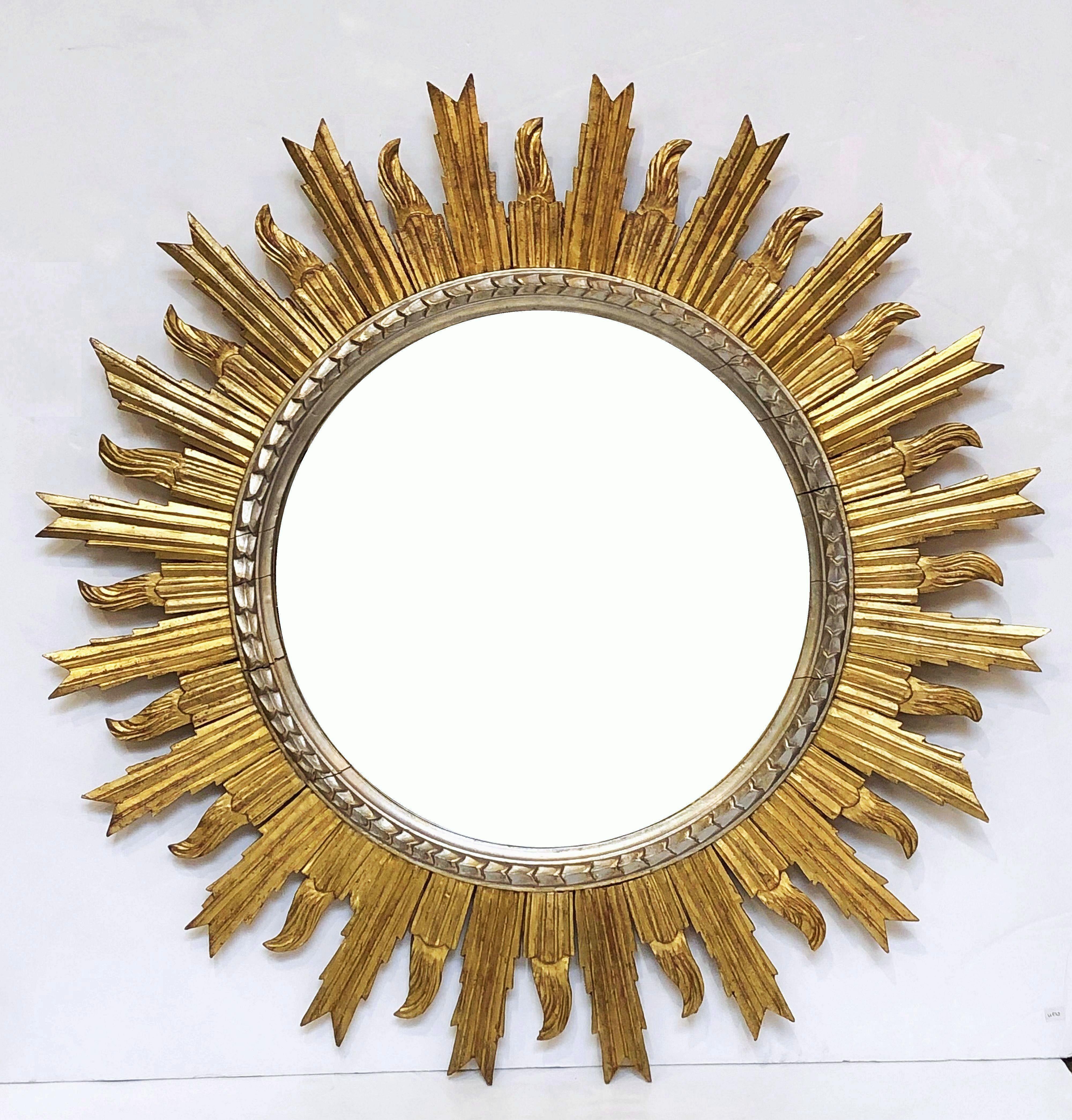 A lovely French gilt sunburst (or starburst) mirror, 36 inches diameter, with round mirrored glass centre in moulded silver frame.