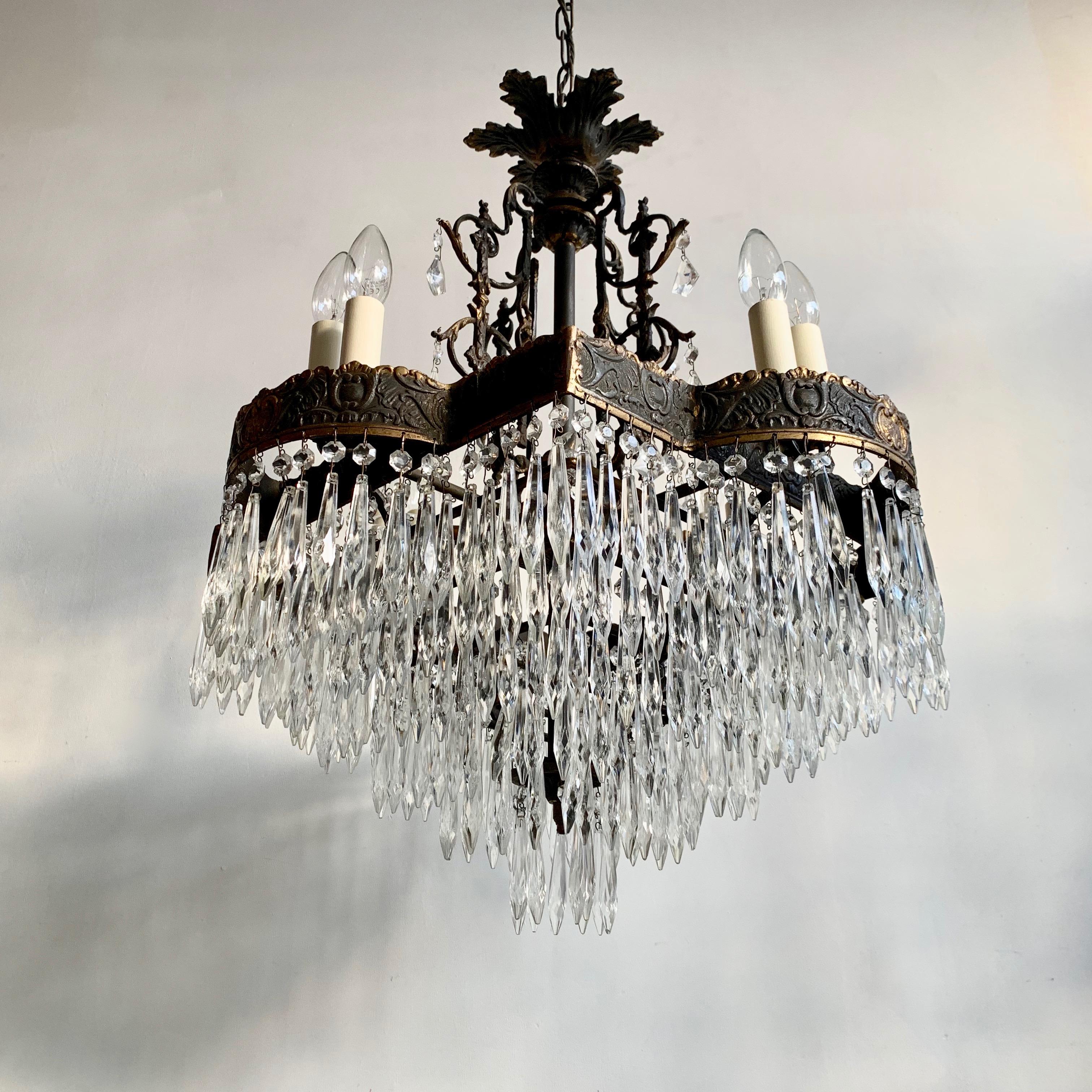 Large French Square French tiered waterfall chandelier with glass icicle drops. An unusual cast brass decorative frame with decorative patterned scrolls, the edging of the frame has a polished border and highlighted details. The center stem is