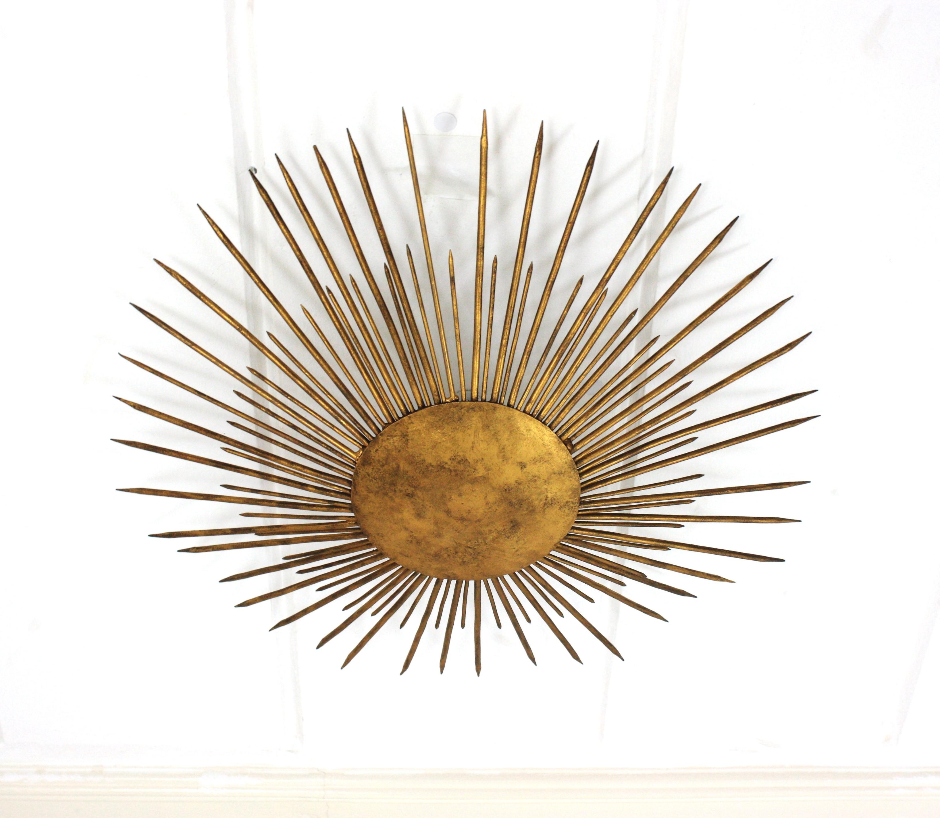 Gran lámpara neoclásica francesa moderna con detalle de pinchos, Francia, años 40
Esta impresionante lámpara de techo de hierro dorado martillado a mano se fabricó a finales del periodo Art Déco. Tiene acentos en transición al estilo Brutalista. 
Un