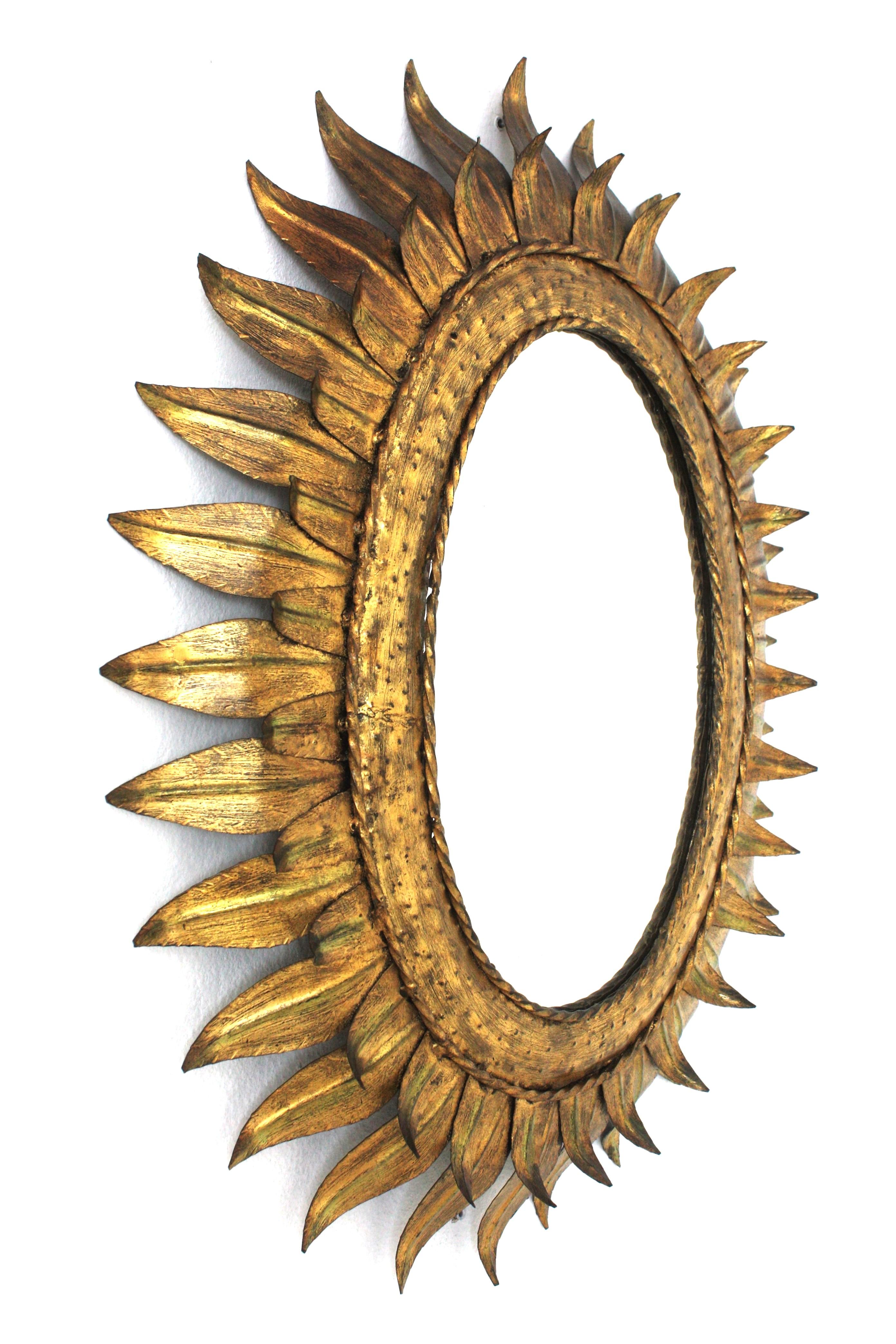 Gran espejo oval francés Sunburst de metal dorado con marco de doble hoja, años 50 Moderno de mediados de siglo en venta