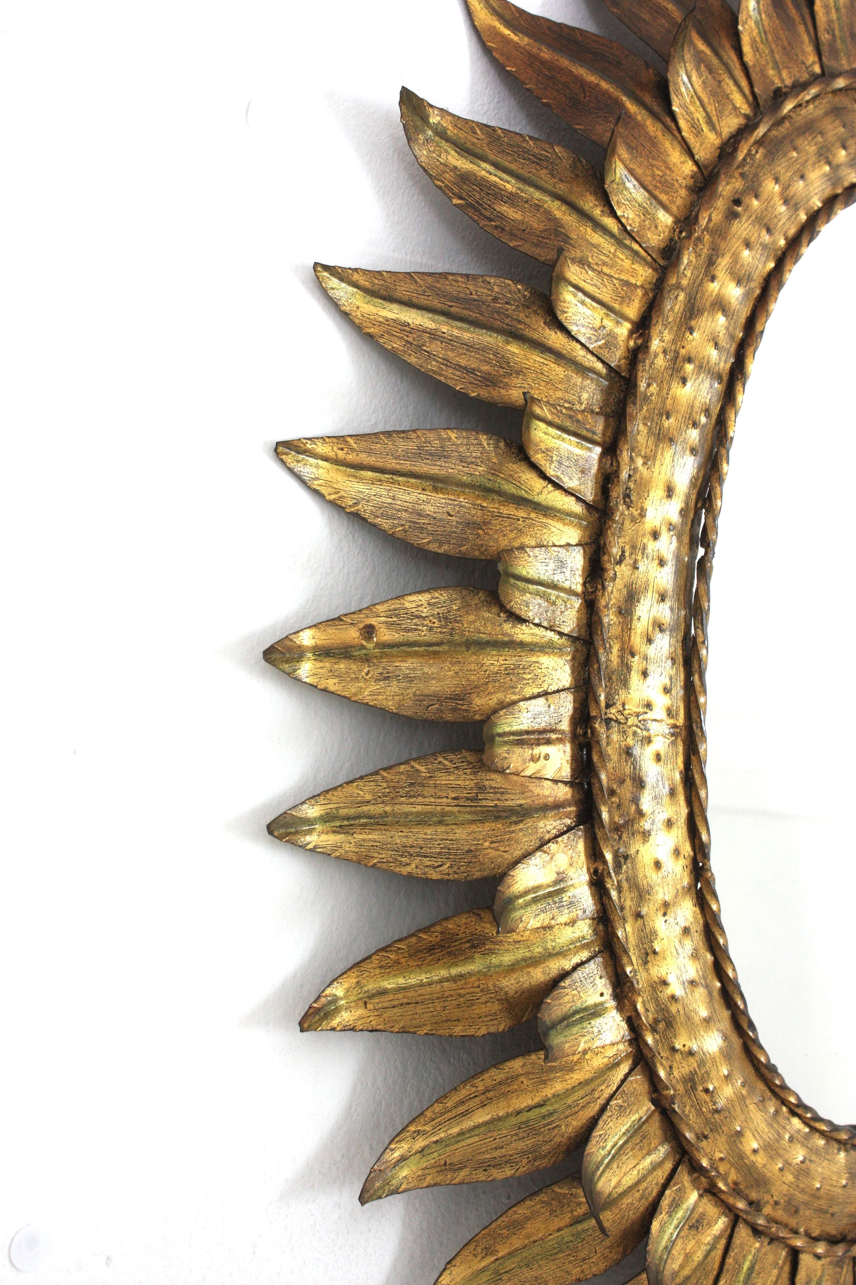 Gran espejo oval francés Sunburst de metal dorado con marco de doble hoja, años 50 Francés en venta