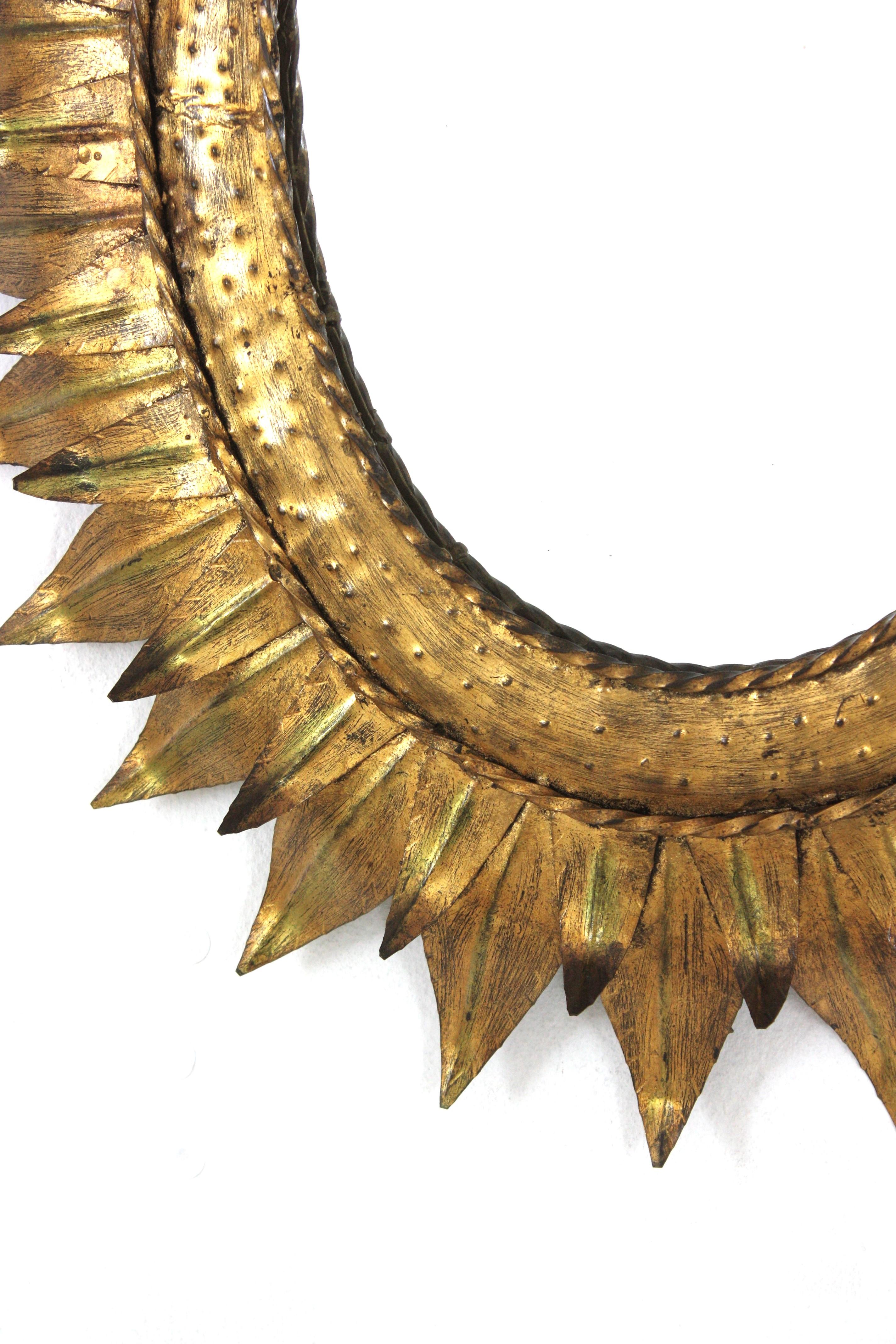 Gran espejo oval francés Sunburst de metal dorado con marco de doble hoja, años 50 Metal en venta