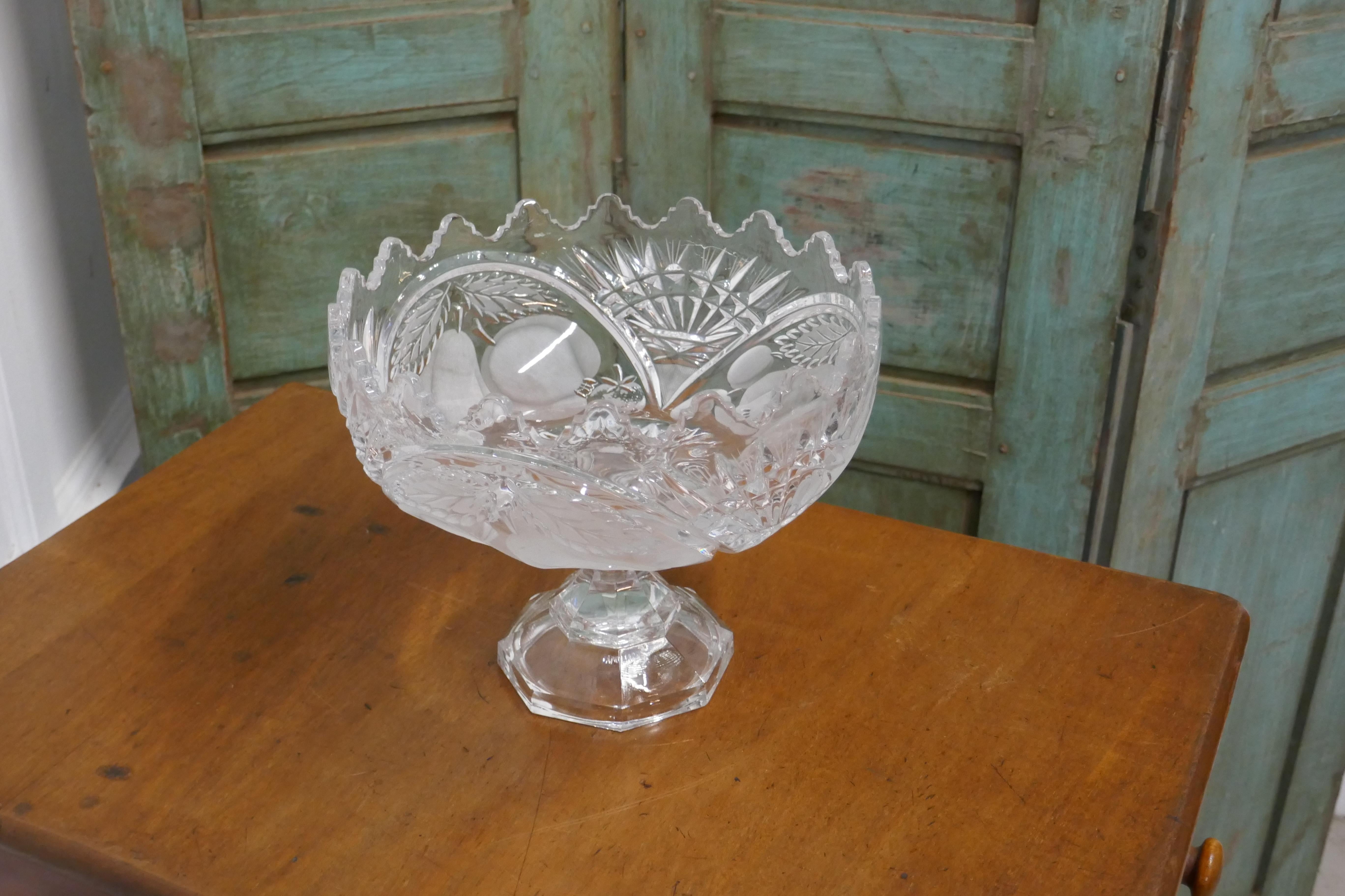Large French Tazza etched crystal pedestal fruit dish

A beautiful piece of etched crystal showing pictures of fruits, the dish stands on a heavy stepped base, this piece is in very good condition no scratches or marks
The dish is 8” tall and 10”