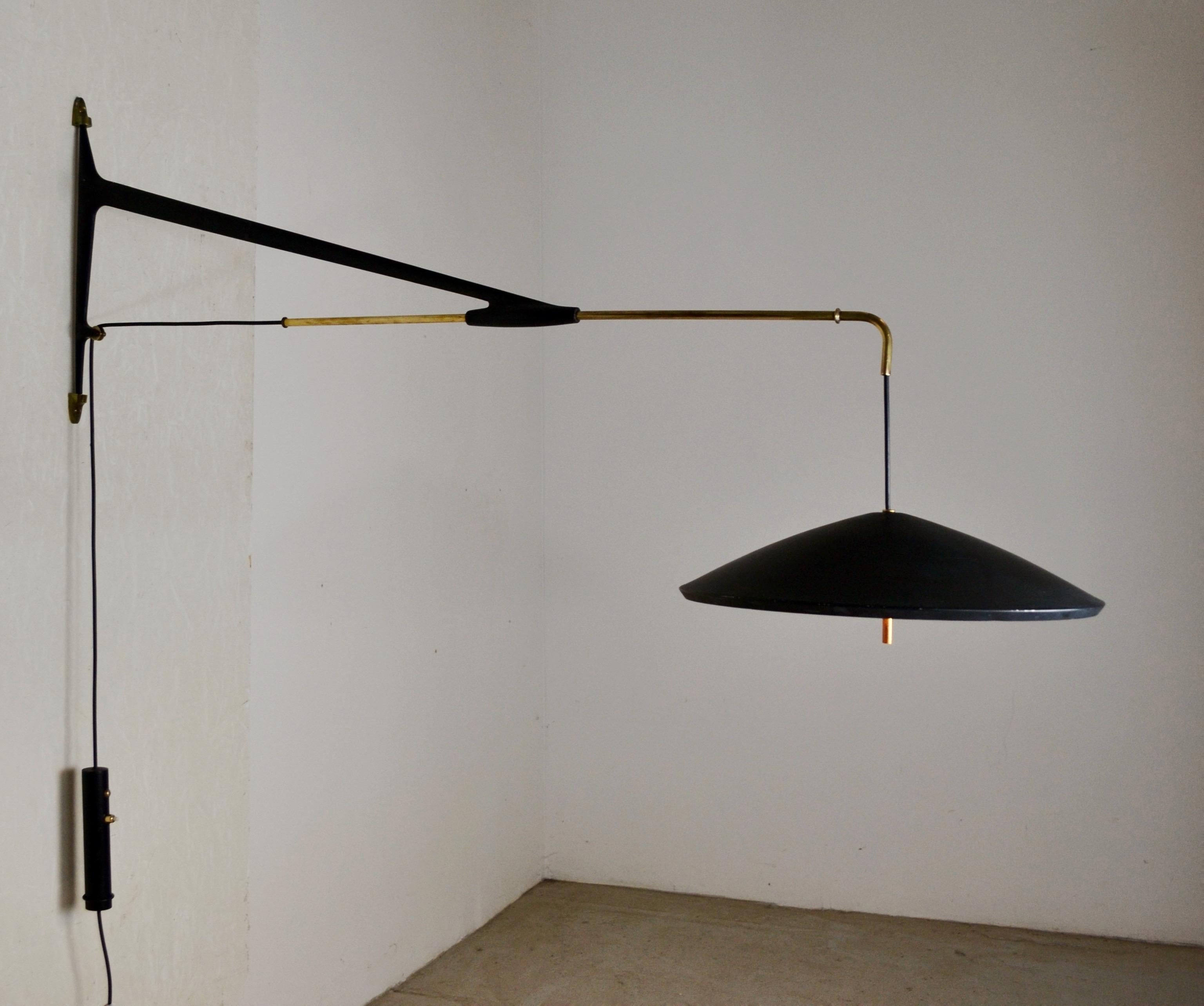 Elegante y funcional, este gran aplique telescópico fue diseñado por Arlus en Francia durante la década de 1950.
Presenta una estructura de aluminio fundido lacado en negro (pintura original), con un brazo telescópico y un sistema de fijación mural