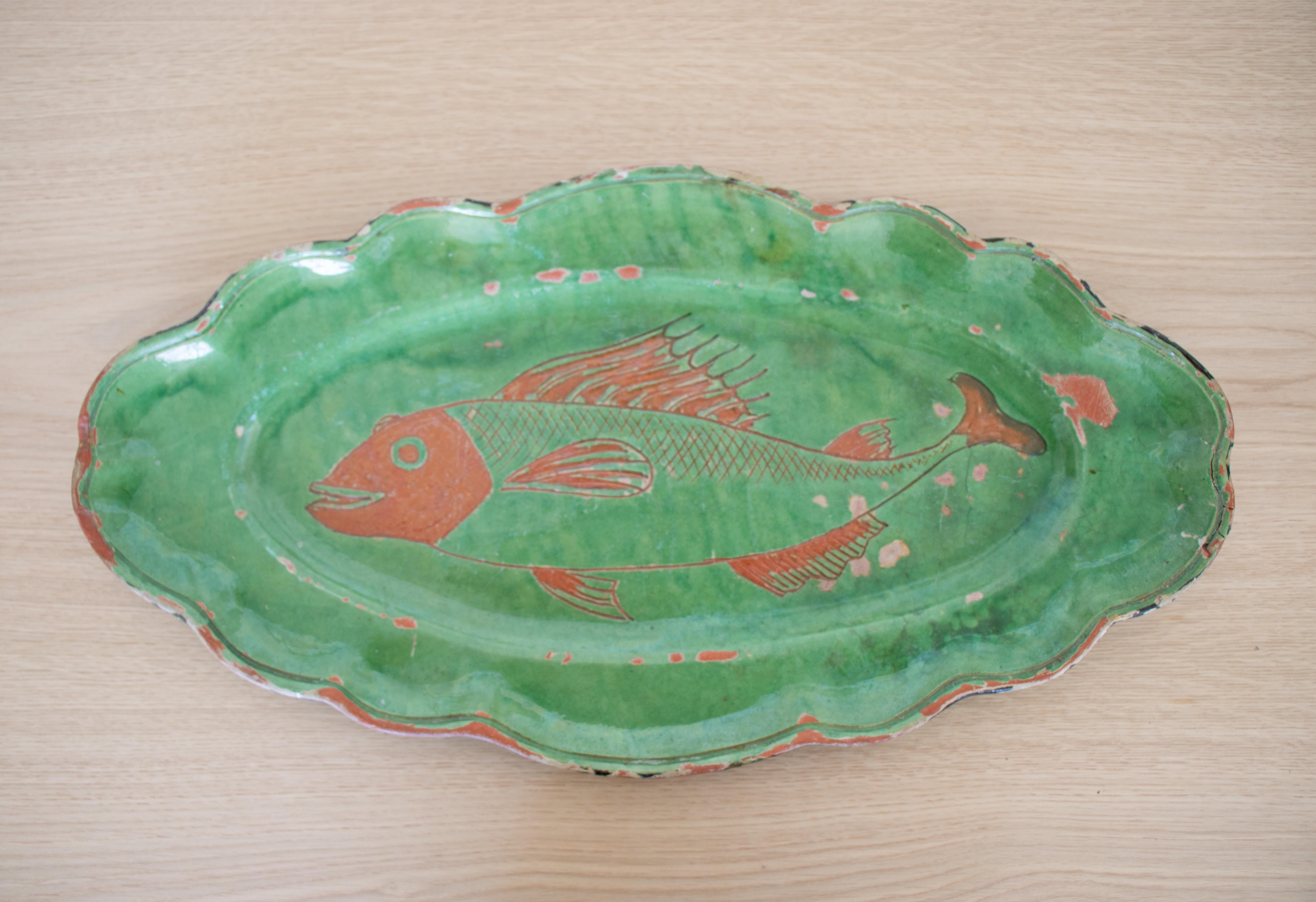 Large French terracotta oval platter with original chipped green paint and a fish motif in the center. Fun and unique center piece with scalloped edge.