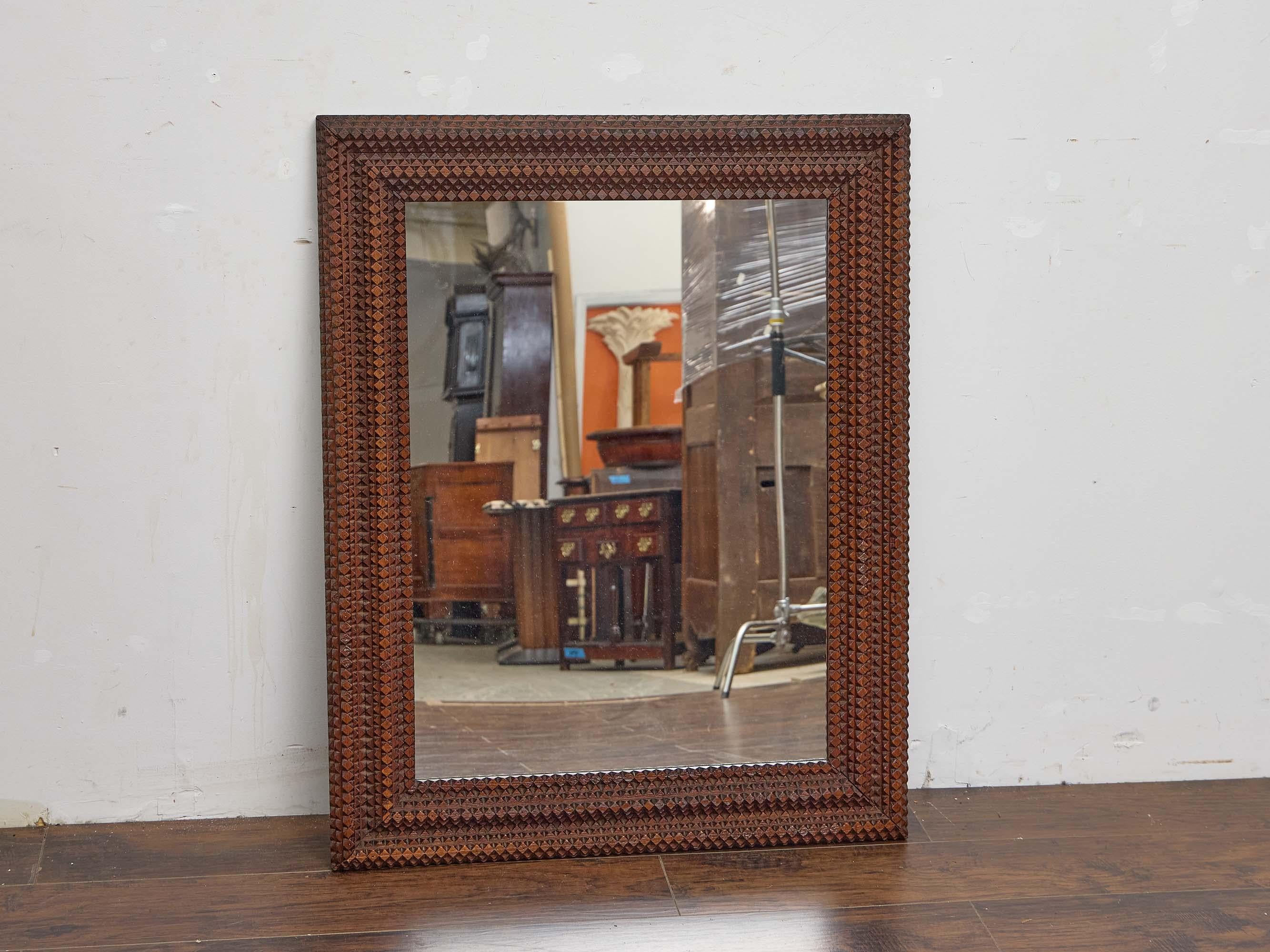 Un sostanzioso specchio francese Tramp Art risalente al 1900 circa, con una cornice riccamente strutturata composta da legno profondamente intagliato disposto in fasce meticolosamente stratificate. Con una larghezza di 33,25 pollici e un'altezza di