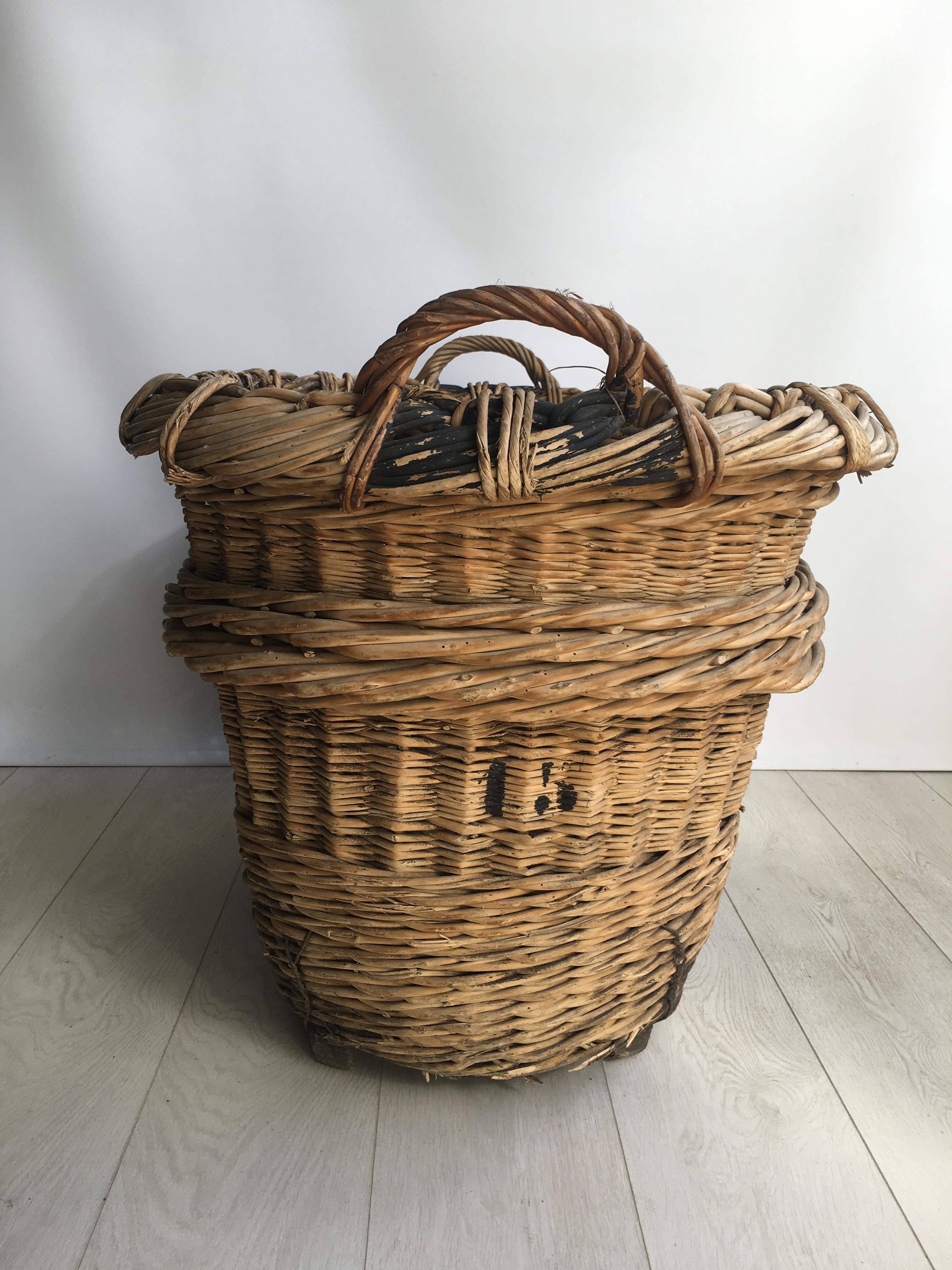 Beautiful heavy duty wicker baskets from the vineyards of Champagne region in France 

Lovely decorative baskets bound on wooden feet, very sturdy (some old woodworm holes, the entire basket has been treated)

Perfect fireside as a log/blanket