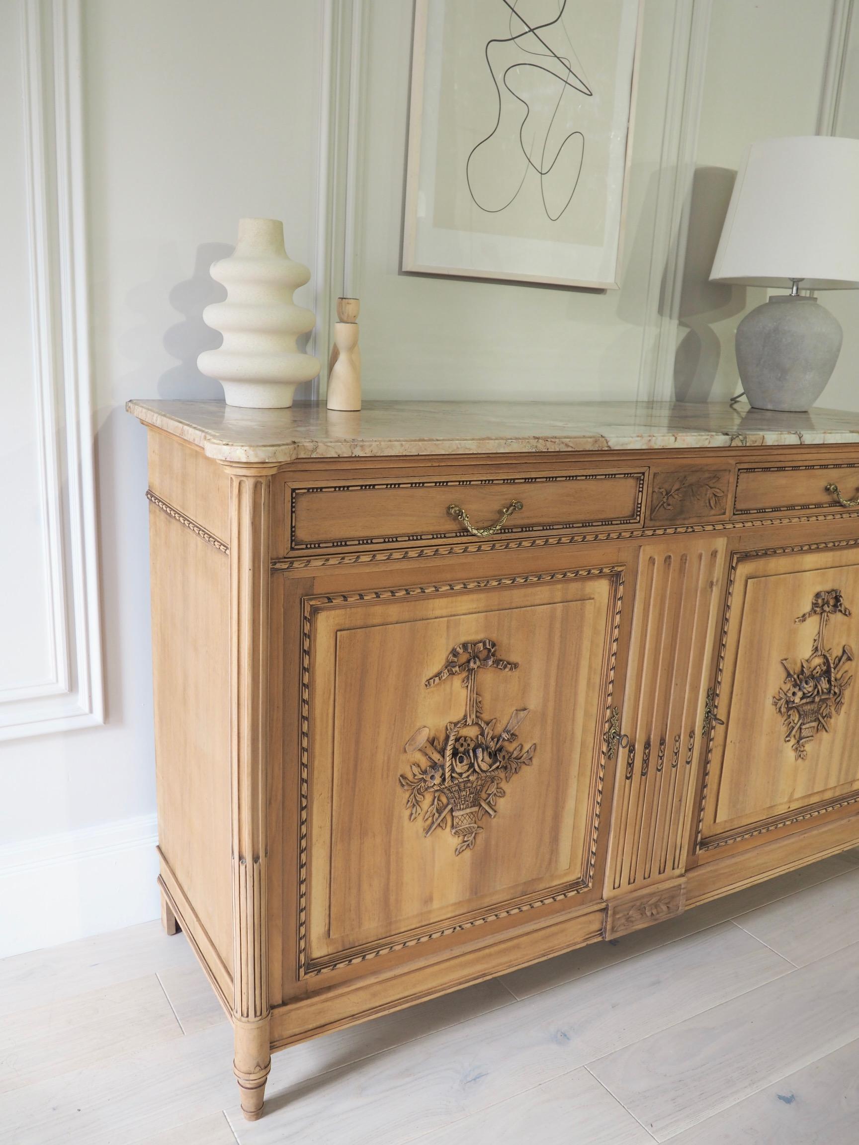 A stunning French antique sideboard in raw wood with a cream slab of marble sitting on top. 



It has been fully sanded back to reveal the beautiful wood grain; inside sits a wooden shelf and two upper drawers; all clean inside. The cupboard