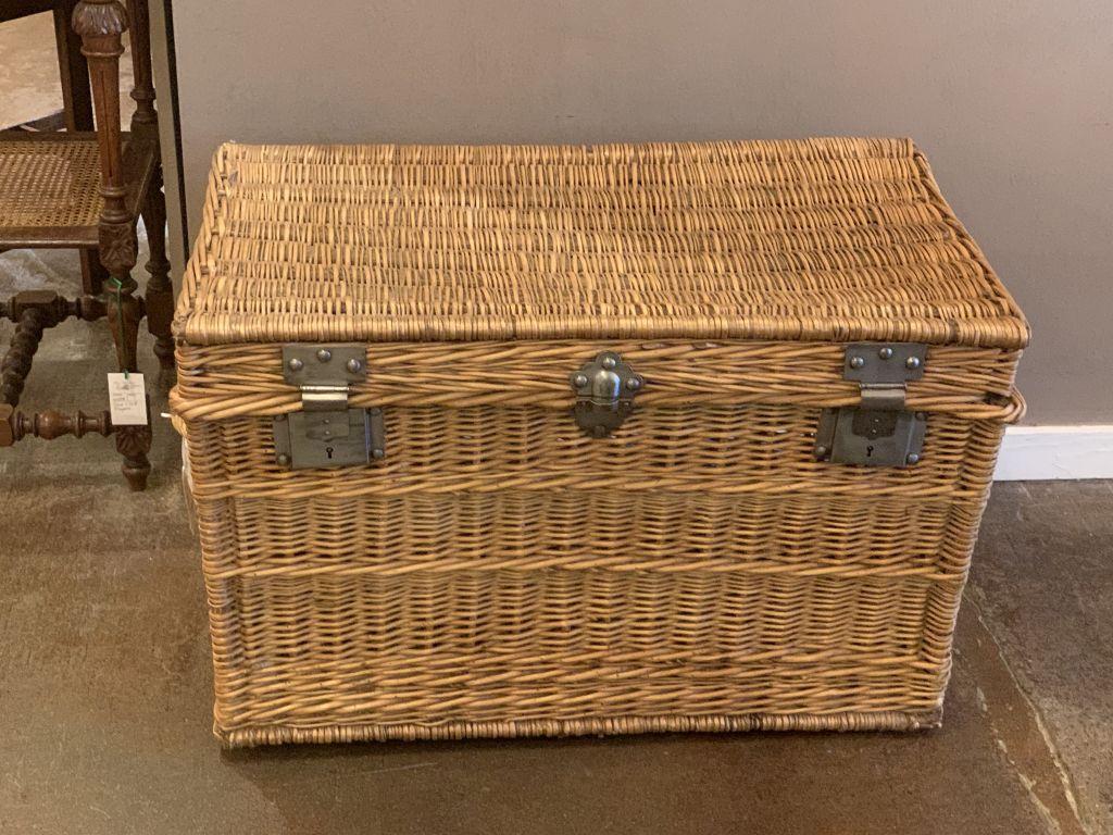 A large French basket hamper of woven willow with steel hardware and handles on each side. With wooden runners on underside.

Several available in this style, slight variations of size.

Note: Latches do not always close and lock but this example