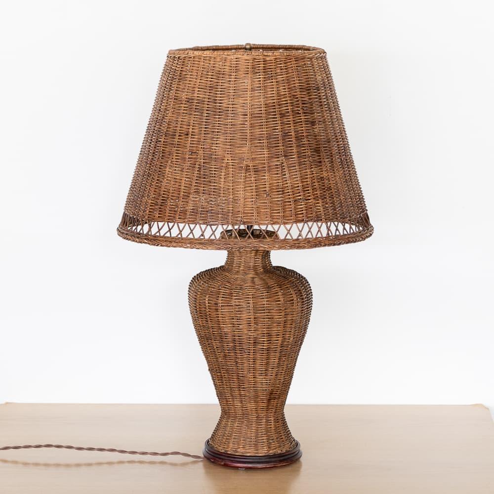 Beautiful large wicker table lamp from France, 1960s. Woven wicker shade with lovely cross detail along edge. Curvy wicker body on a round wooden base. Dark brown stain on wicker shows nice age and patina. Newly re-wired. Takes one E26 bulb, 60 W or
