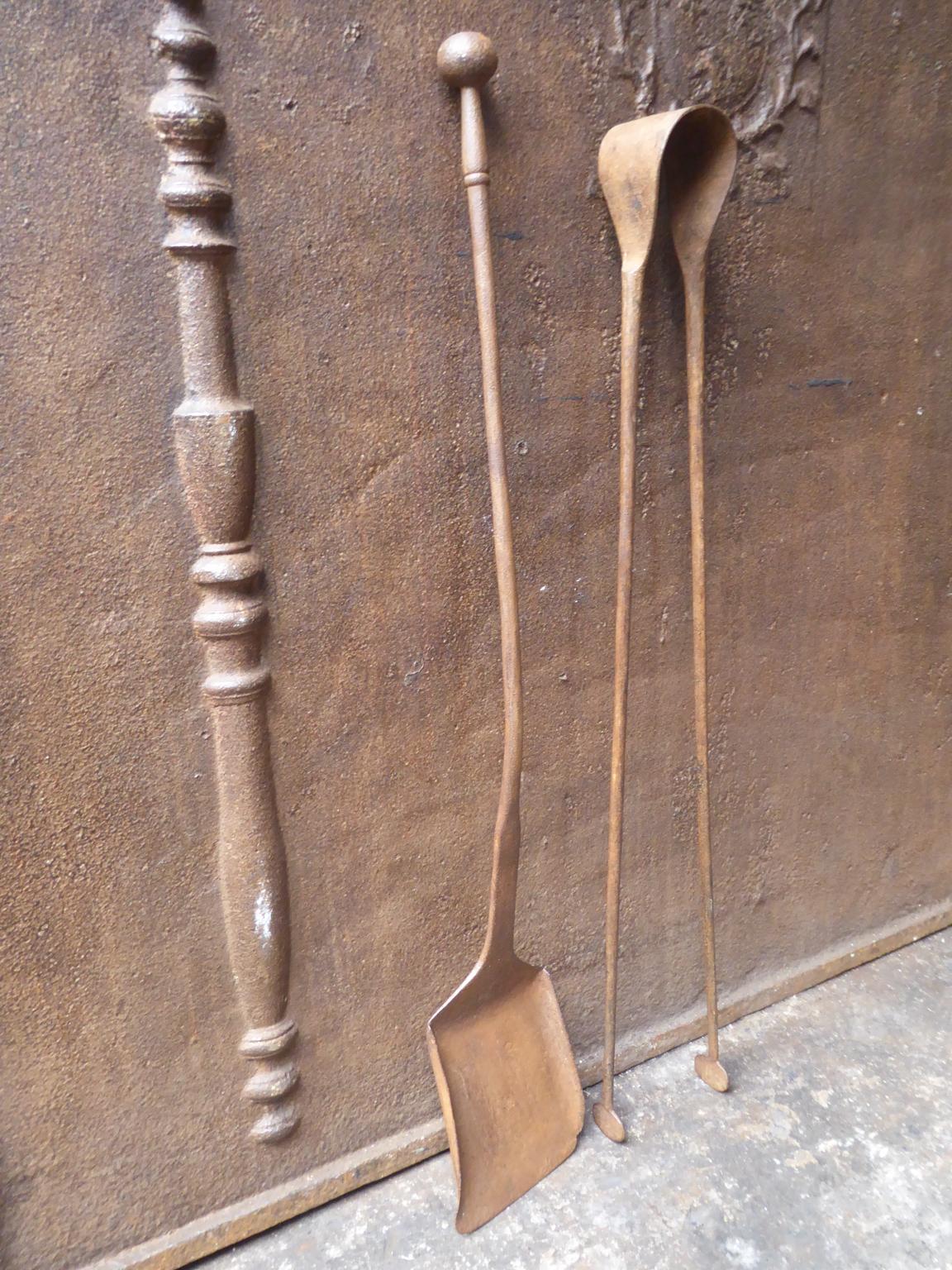Large 18th century French Louis XV fireplace tool set consisting of fireplace tongs and a shovel. The fire irons are made of wrought iron. They are in a good condition and are fully functional.