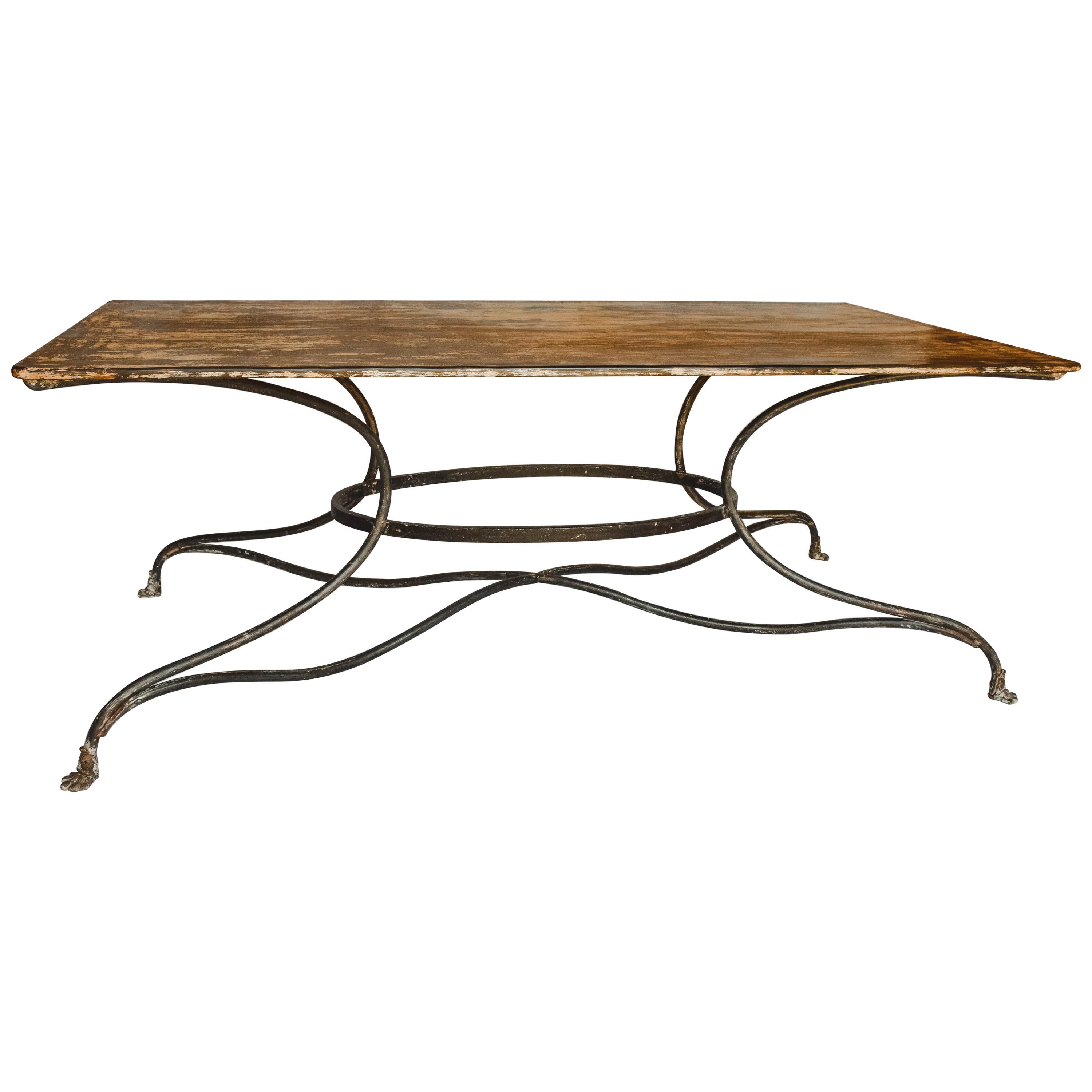 This French garden table with unusual rectangular top from the early 20th century is from Arras, a city located in Northern France. The table is supported by a quadripod base. The ensemble is raised on four paw feet. The crusty finish shows traces