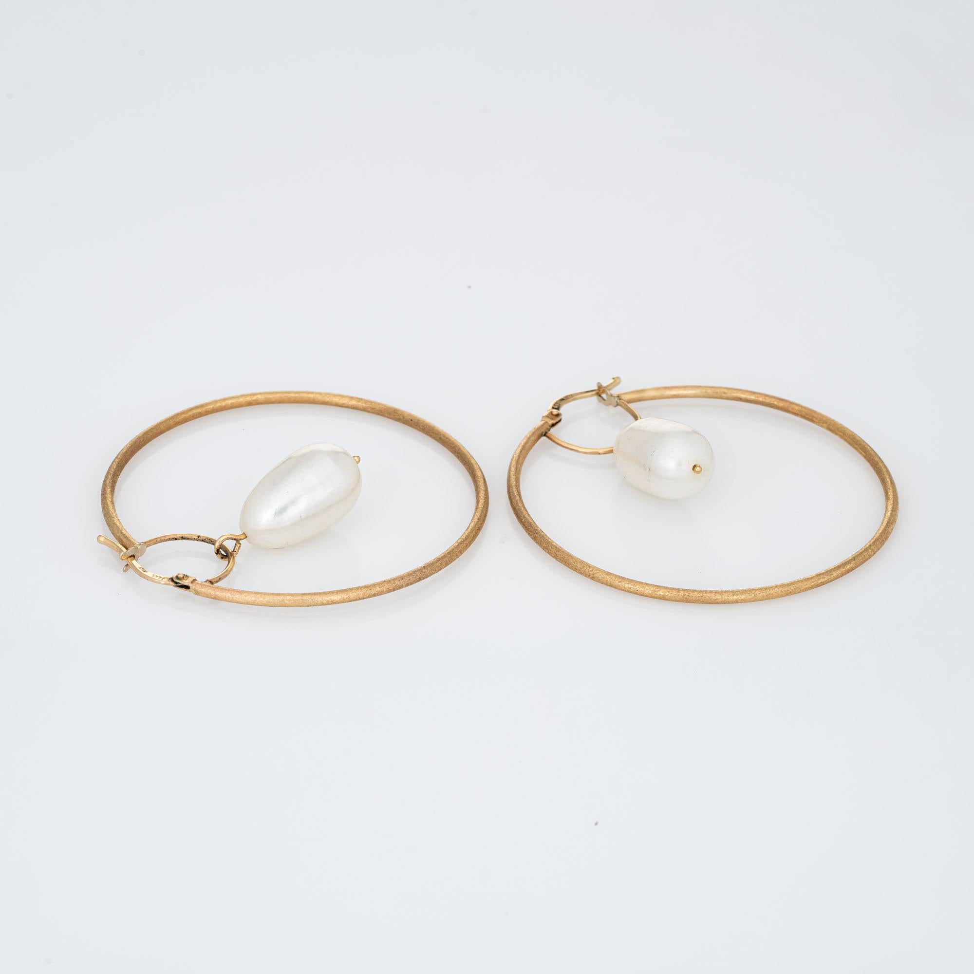 Elegant pair of estate freshwater pearl hoop earrings crafted in 14k yellow gold. 

Freshwater pearls each measure 15.5mm x 9mm. The pearls are well matching with light green to rose overtones. 

The pearls are uniquely set into semi-circle drops