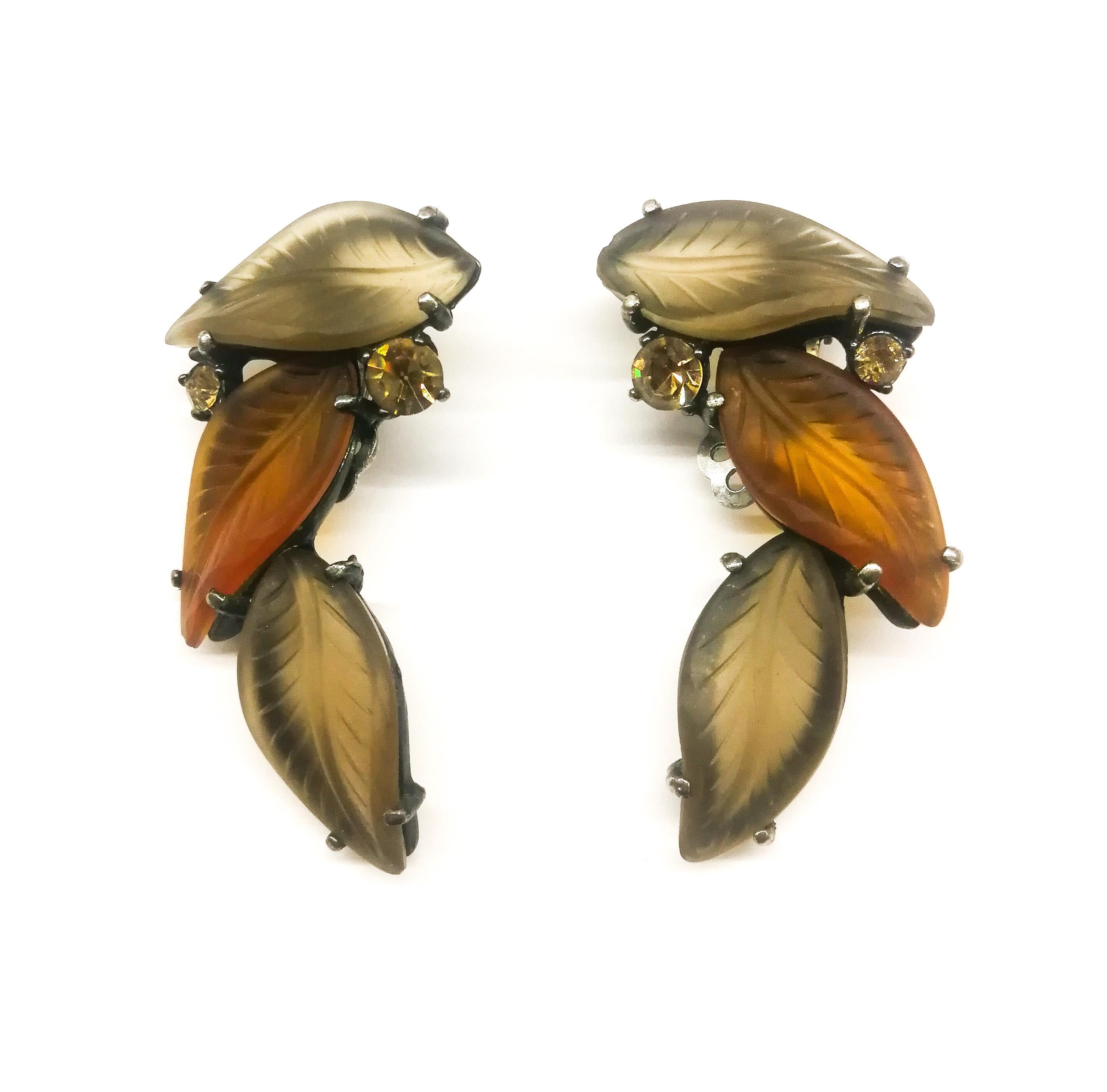 These sumptuous earrings are from the later period of Schiaparelli design, in the 1950s, but are one of her most striking and elegant creations. Reminiscent of Lalique glass, in soft, warm tones of brown, they sit beautifully on the ear, flat and