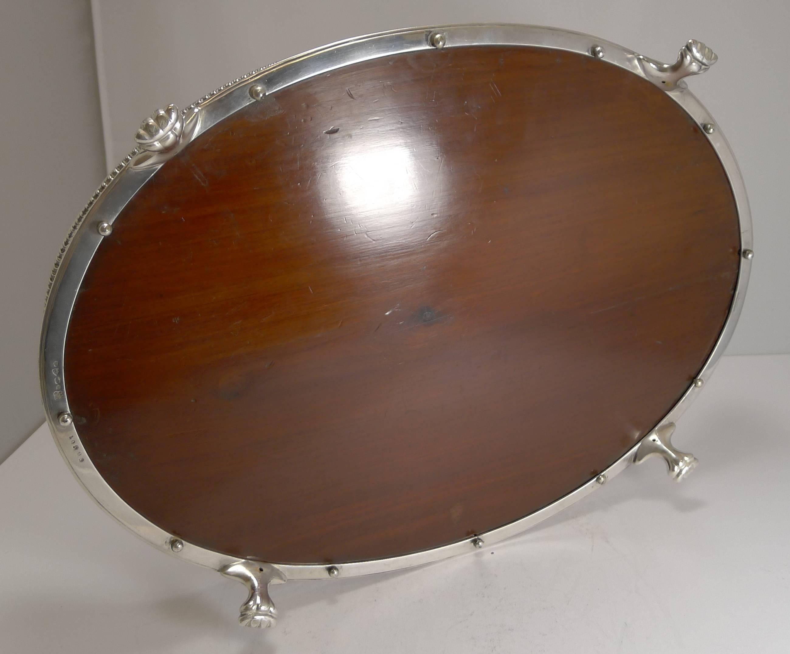 A top-notch late Victorian galleried tray made from fruitwood and silver plate.

The gallery is beautifully pierced or reticulated with stylish cut-out handles to each end. The tray sits of four magnificent and grand Lion's paw feet and the
