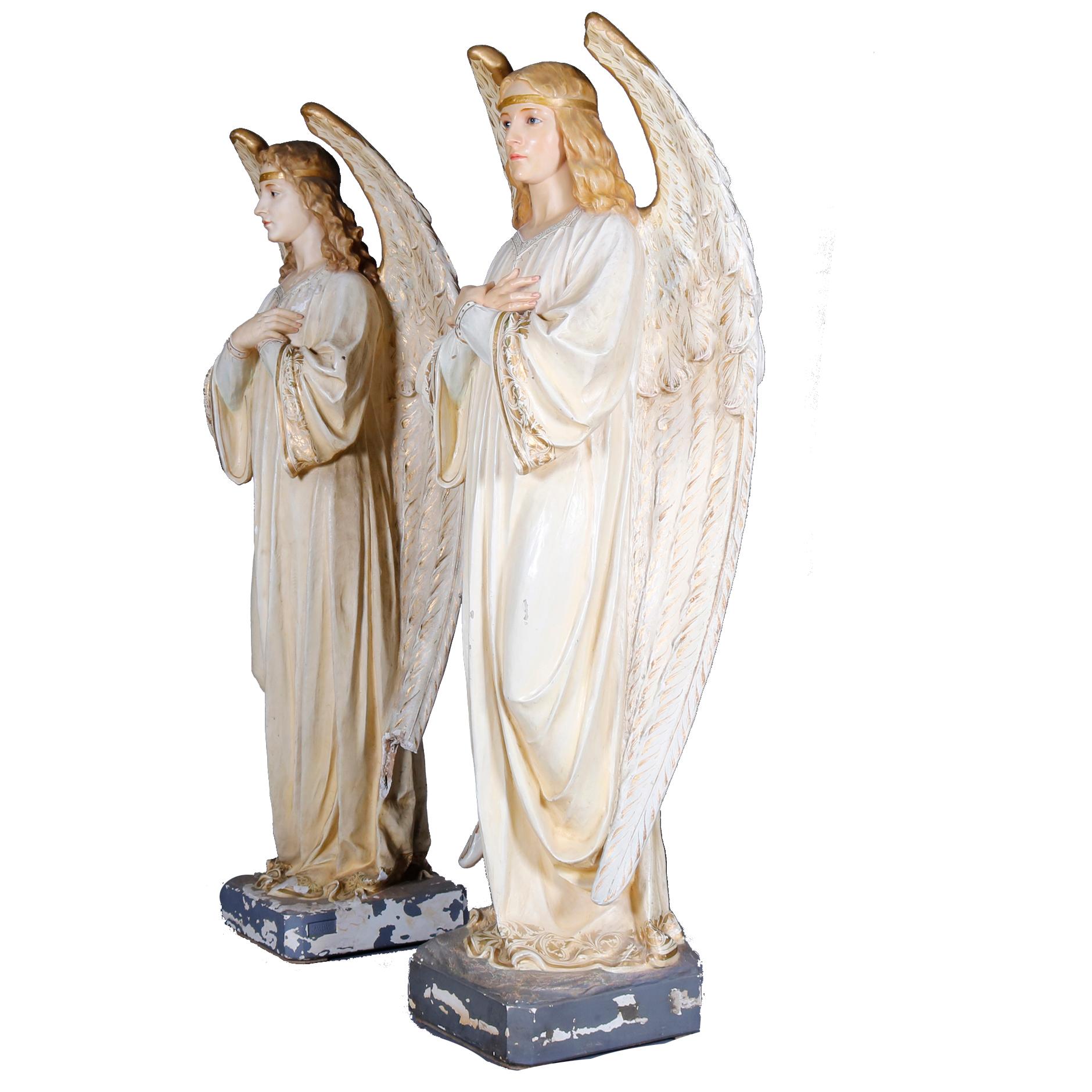 An antique and large pair of life size hollow cast plaster sculptural statues offer hand painted and gilt Christian figures of angels, en verso label reads 
