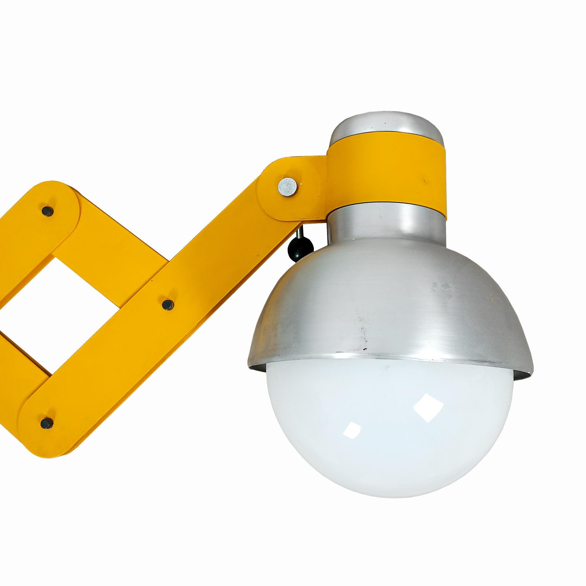 Large fully adjustable accordion wall lamp in yellow lacquered steel. Parts in chromed metal and adjustment handles in black plastic. Large white opaline ball and brushed aluminium lampshade.

Design: Ramon Bigas Balcells.

Spain, Barcelona c. 1970.