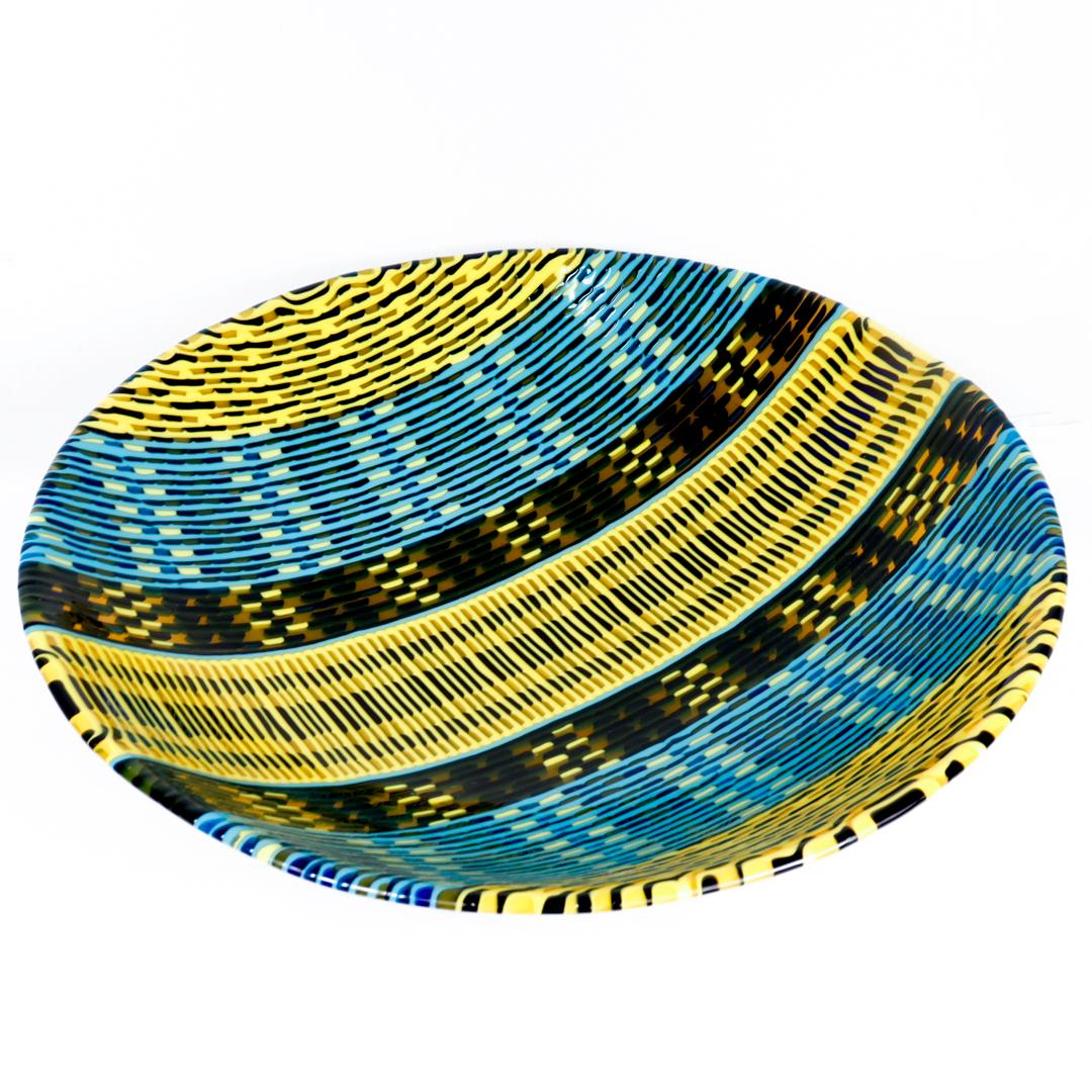 A fine American art glass bowl.

By the Pittsburgh artist Jeffrey Phelps. 

Entitled: Navajo Weave

In the form of a large, low bowl comprised of fused black, yellow, and blue glass murrines. 

Phelps is widely exhibited with work in both public and