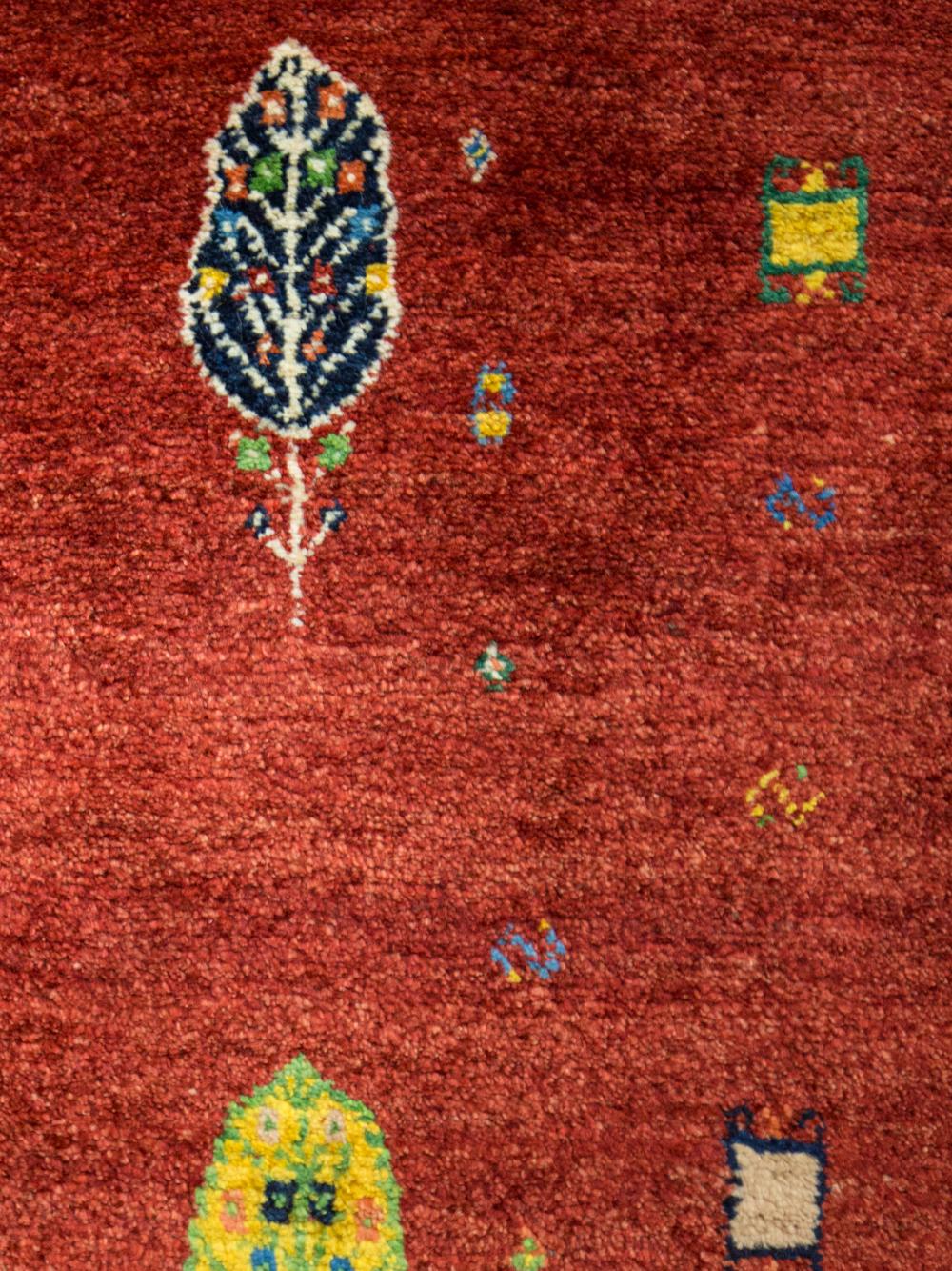 Large Red Contemporary Tribal Pattern Gabbeh Persian Wool Rug. Truly a crossover of floor covering and art, this Gabbeh could pass as a painting depicting an abstract garden scene. We love the tiny, multi-colored cypresses (a sacred tree in Islam)