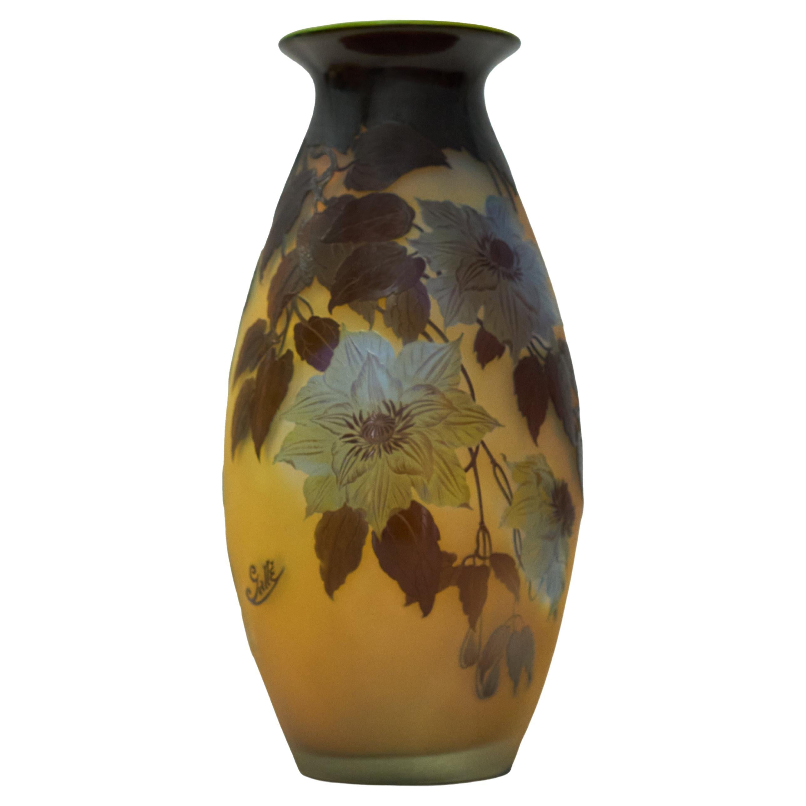 A large and impressive original Art Nouveau Emile Gallé cameo glass vase. colourless glass with a degrading amber layer overlaid in brown blue and green, etched and cut with flower blossom

Marked: Gallé.
