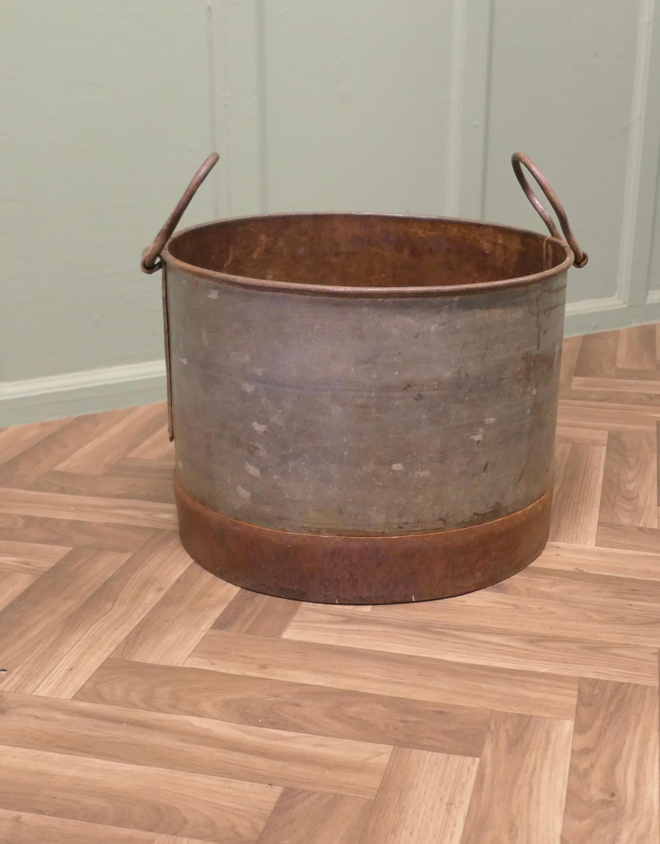 Large Galvanised Steel and Iron Cauldron Log Bin

This is a large galvanised pot it has swing handles for carrying, an unusual piece of brutalist design, this is a strong piece and it would make a great log carrier
The bucket is 13” high and 19” in