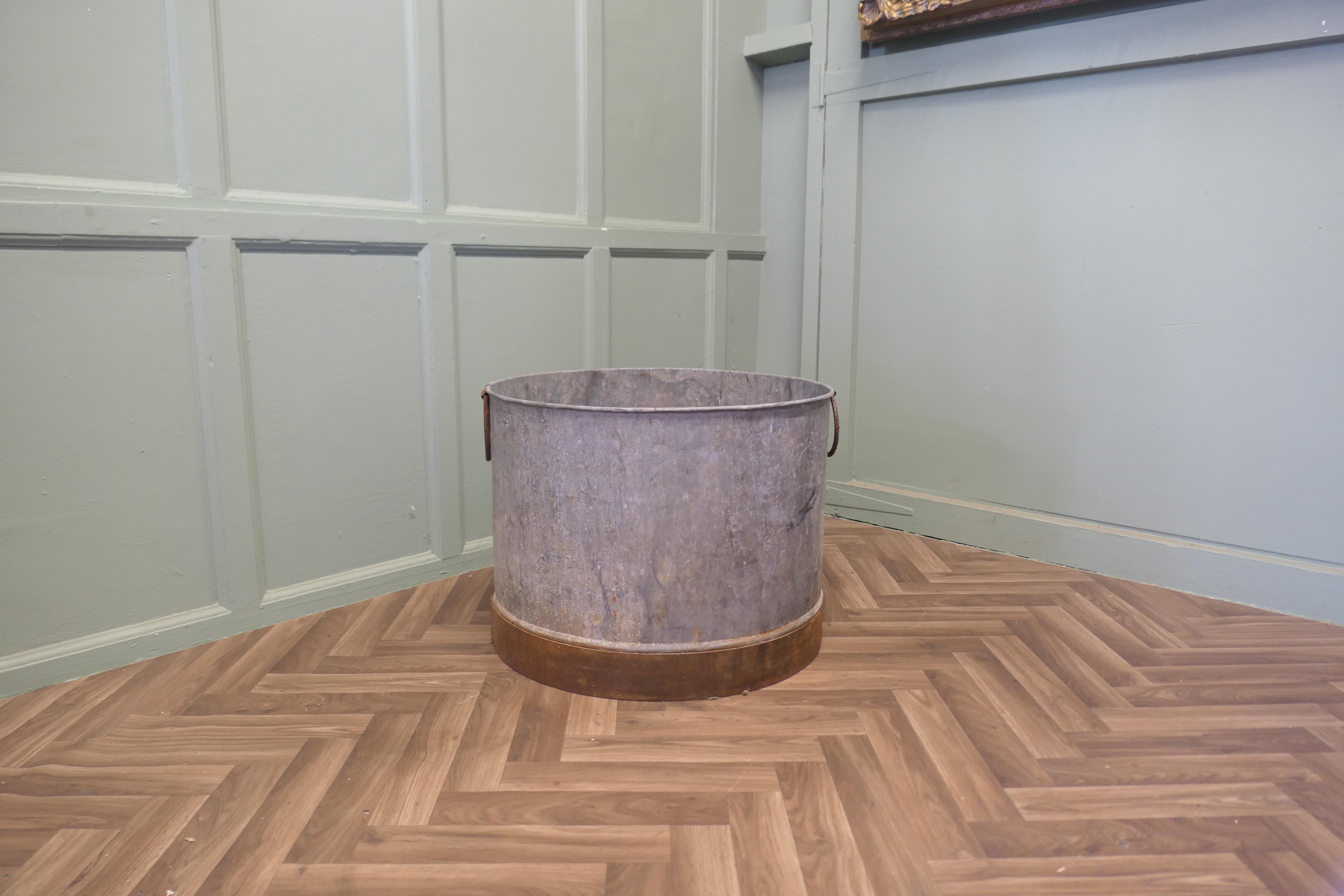 Large Galvanised Steel and Iron Cauldron Log Bin

This is a large galvanised pot it has swing handles for carrying, an unusual piece of brutalist design, this is a strong piece and it would make a great log carrier
The bucket is 18” high and 23” in