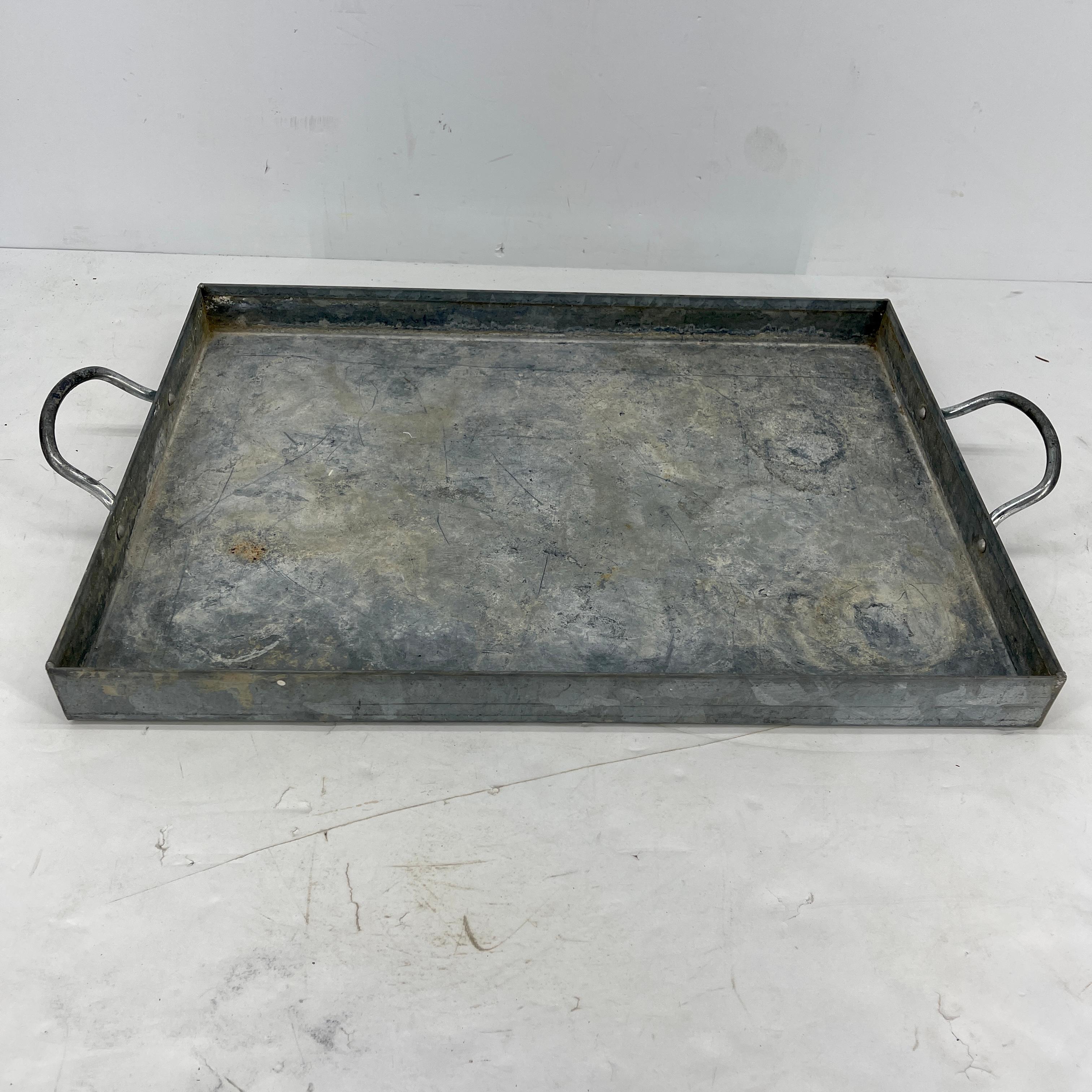 Mid-Century Modern galvanized metal serving bar tray with handles. This large tray is a perfect addition to a bar or as a serving piece for all entertaining needs. The tray is sturdy. The tray is as functional as it is timeless in industrial, boho