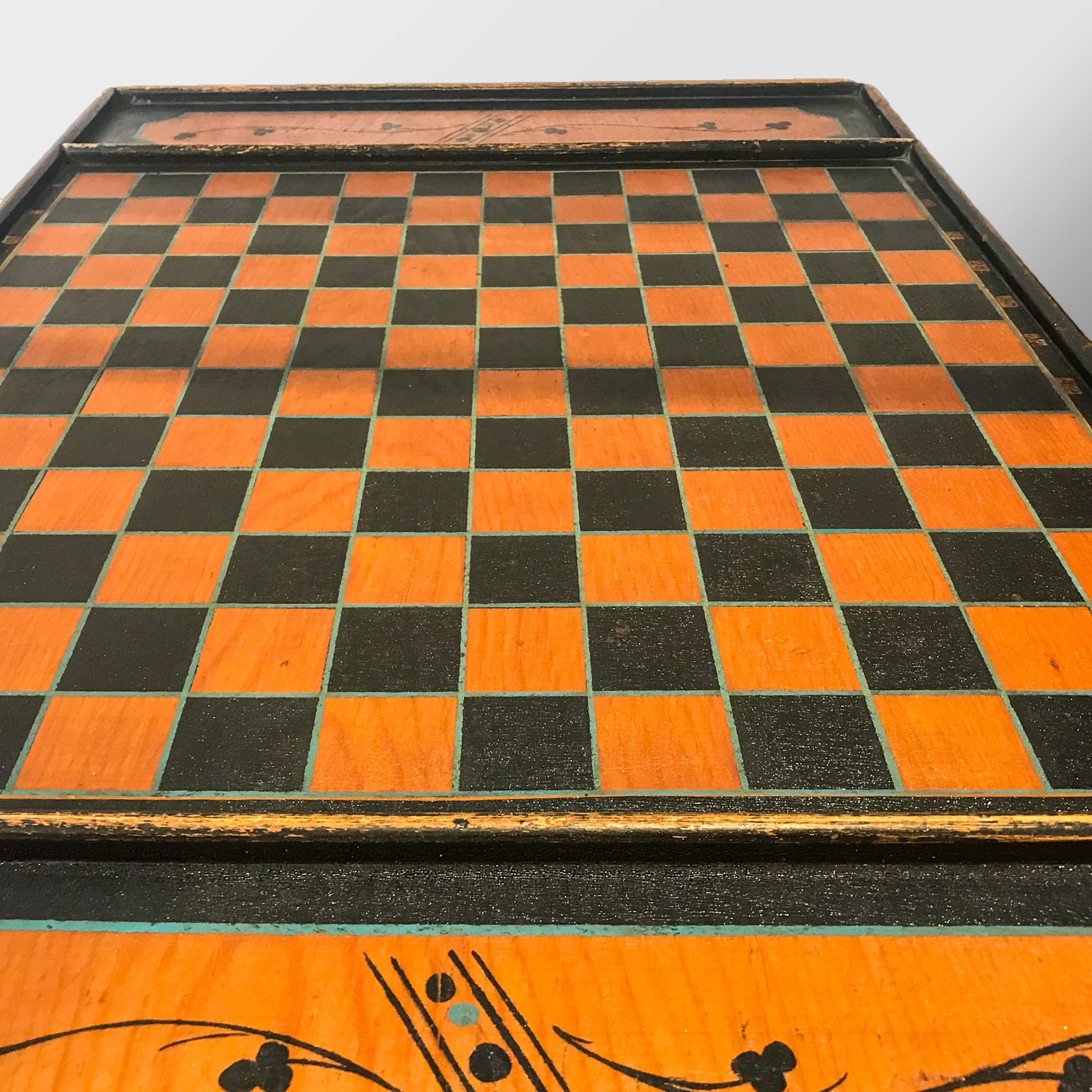 Large paint decorated double sided game board in horizontal form. The checkerboard has black squares with delineated painted blue borders, the columns have applied printed numbers and the reserves are painted with Victorian flourishes. The reverse