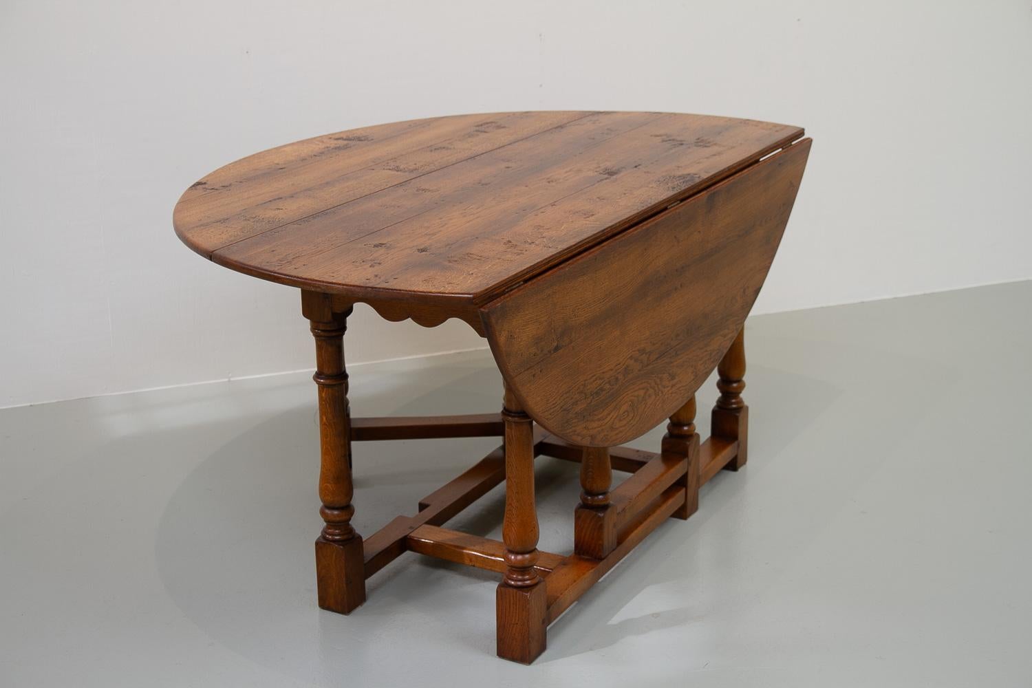 Large Gateleg dining Table in oak with drop leaf top.
Table top is made of solid hand planed oak planks with visible pegs along the joints. Base with turned legs in solid oak. Two legs pivots to support the leaves, hence the name gateleg.
The