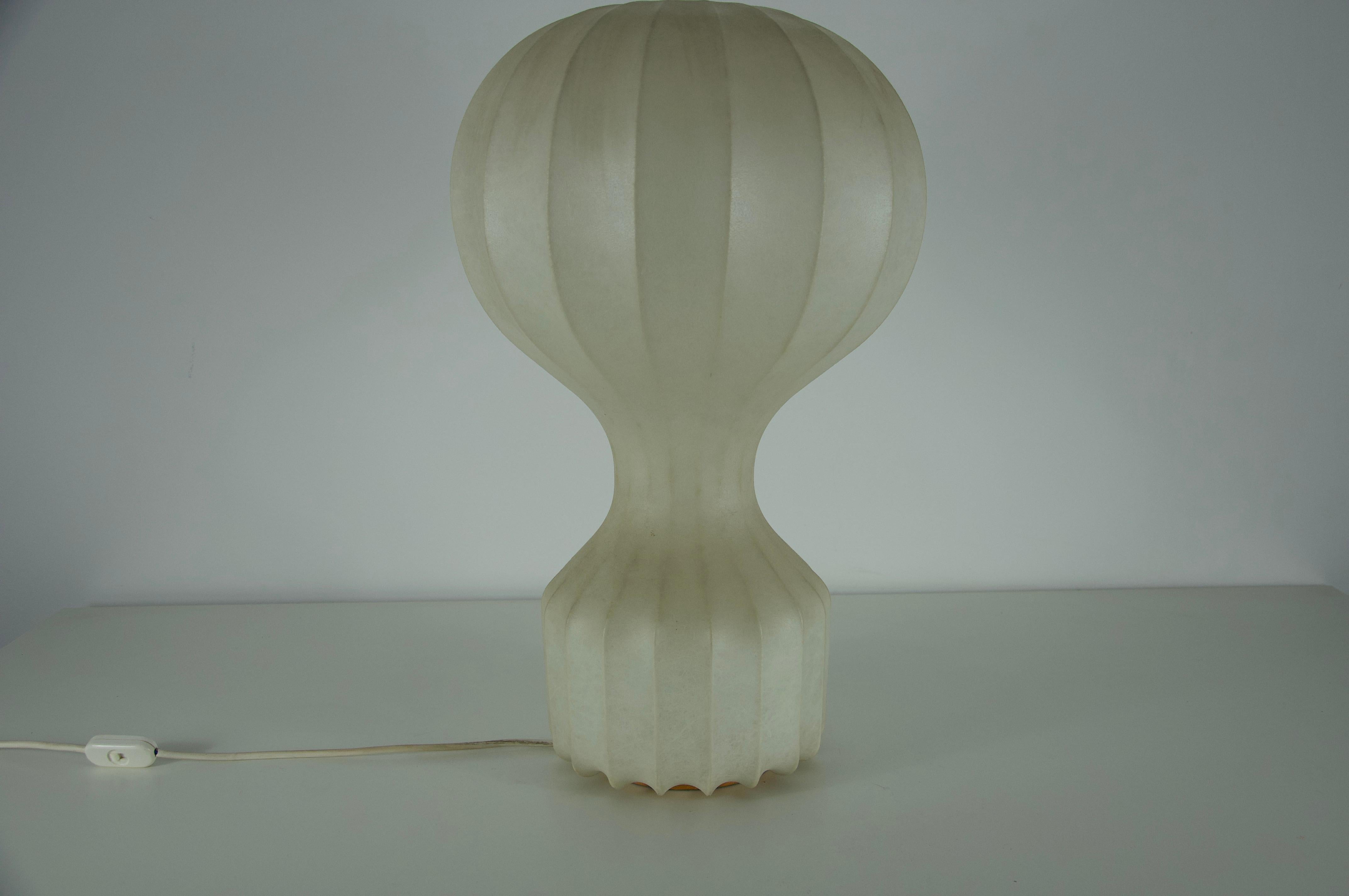 A masterpiece of Italian mid-century design, the “Gatto” table lamp was created by the renowned Achille & Pier Giacomo Castiglioni for Flos in the 1960s. This sculptural lamp features a meticulously crafted enameled steel frame, elegantly encased in