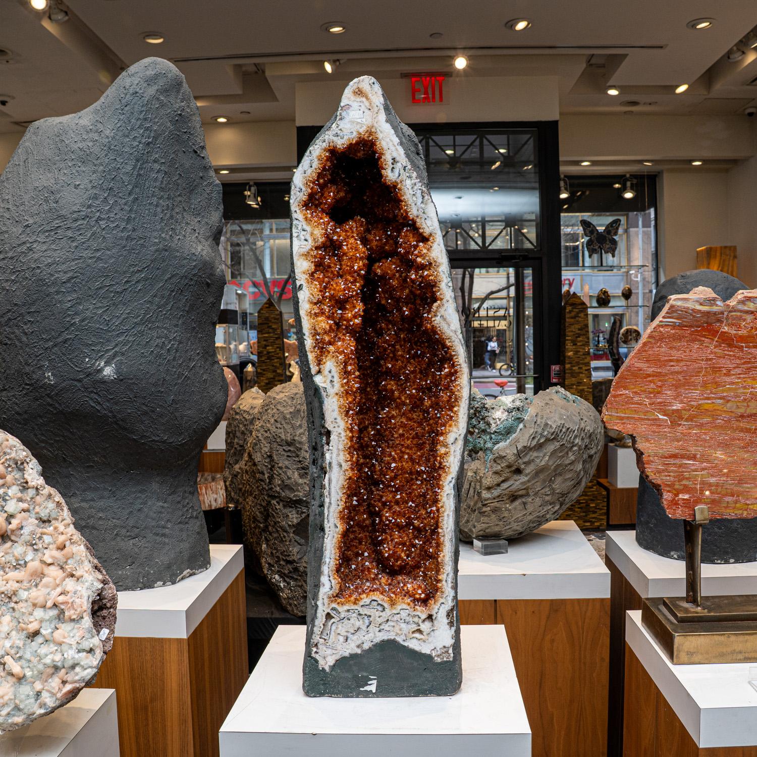 This Massive museum quality, Citrine crystal clustered geode from Brazil is a top quality natural formation of gem citrine. This specimen showcases a full lining of radiant, golden quartz crystals and features vibrant orange and yellow hues with