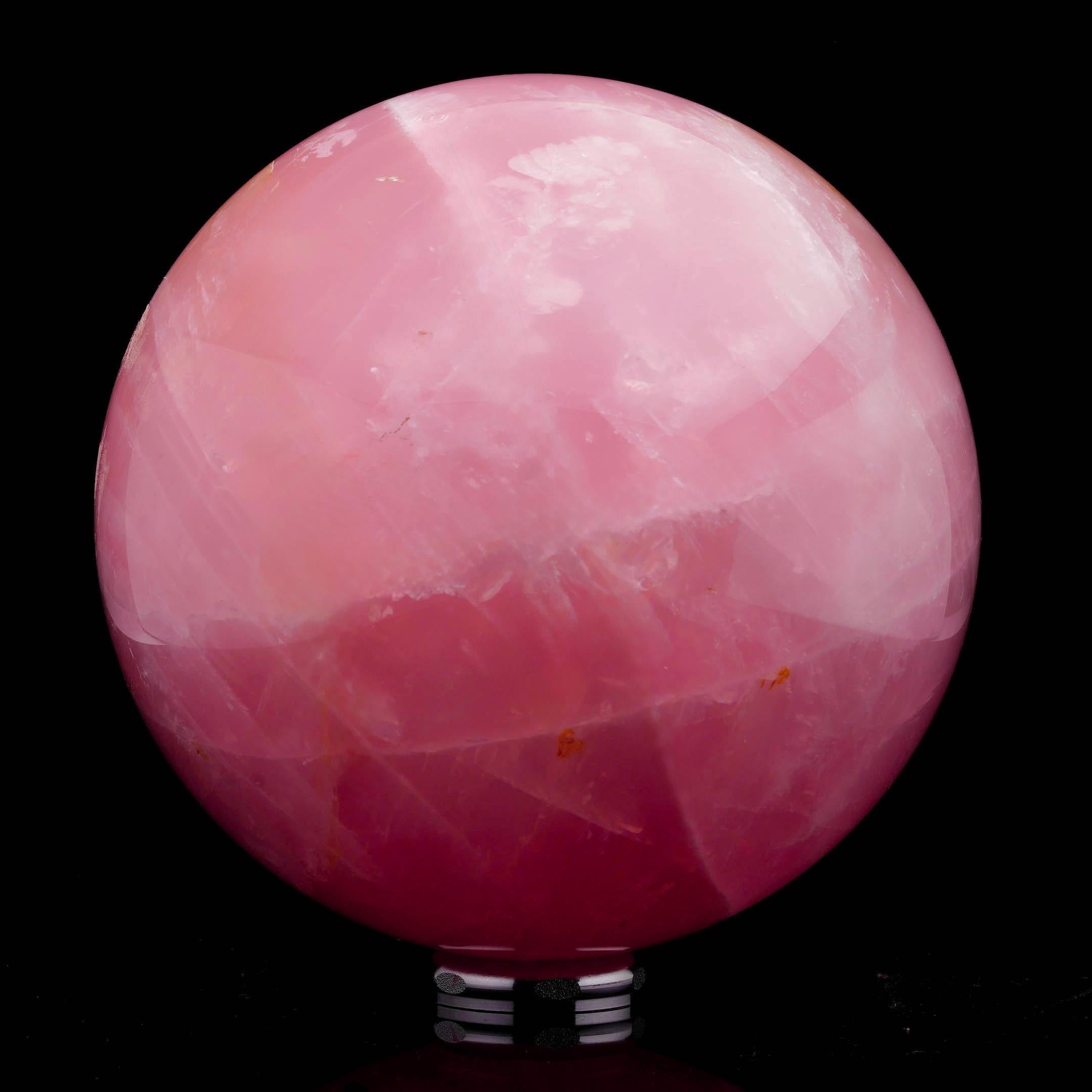 This exquisitely hand-polished Rose Quartz sphere displays a rich, even pink hue. Delicate white veining and subtle translucence juxtapose the saturated pink, white the impressive size and flawless spherical form of the Rose Quartz showcase its
