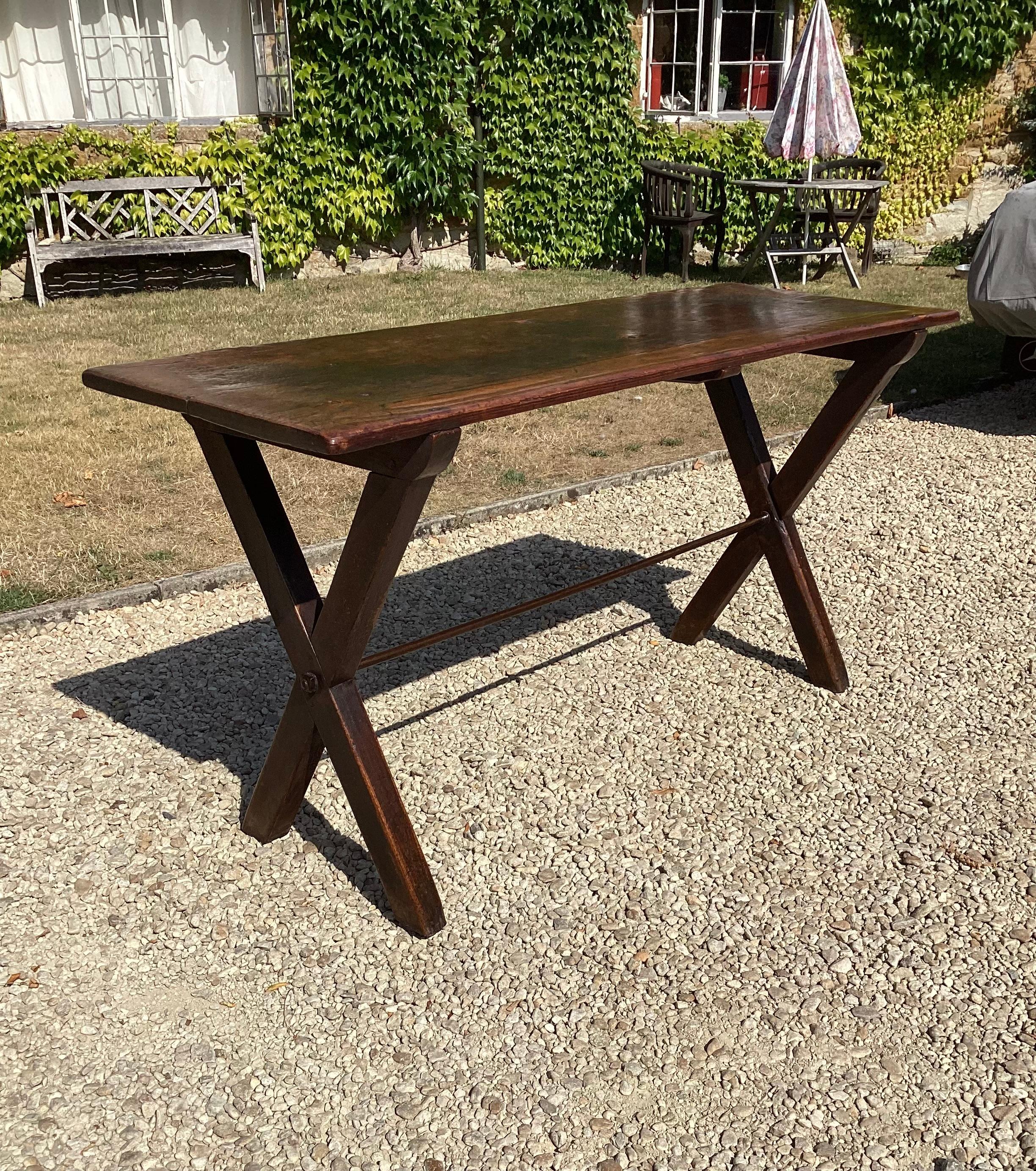 A good Geo III pine tavern table, the one piece top with a rich well built up patina, supported on X-frame supports, still retaining most of the original stained finish and joined by an iron stretcher. In good completely original condition, large