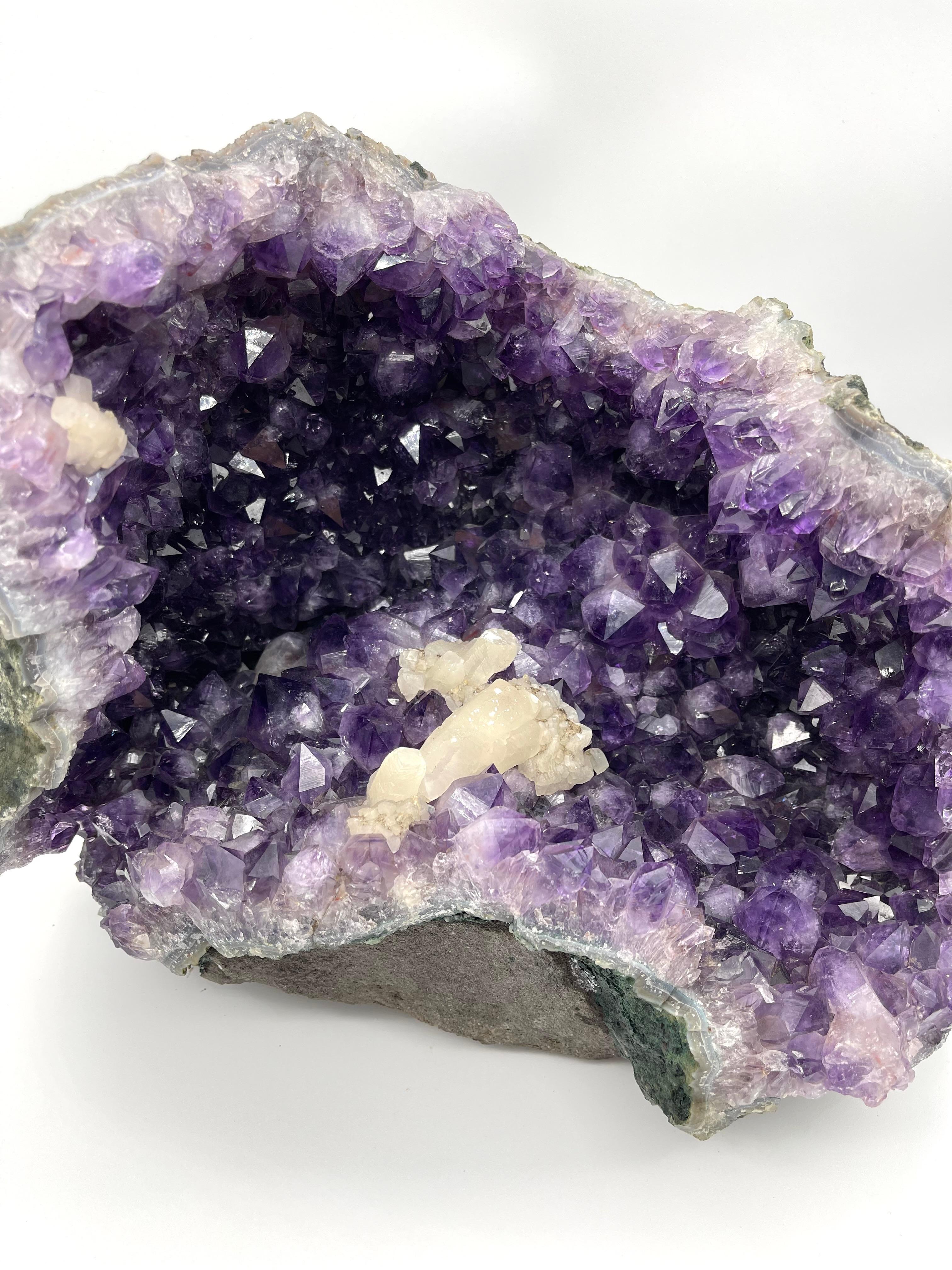 Discover the majestic beauty of this large amethyst geode with quartz inclusion, originating from the Morvan region in France. Weighing an impressive 21 kg, this unique piece is a true wonder of nature that will capture attention and delight mineral