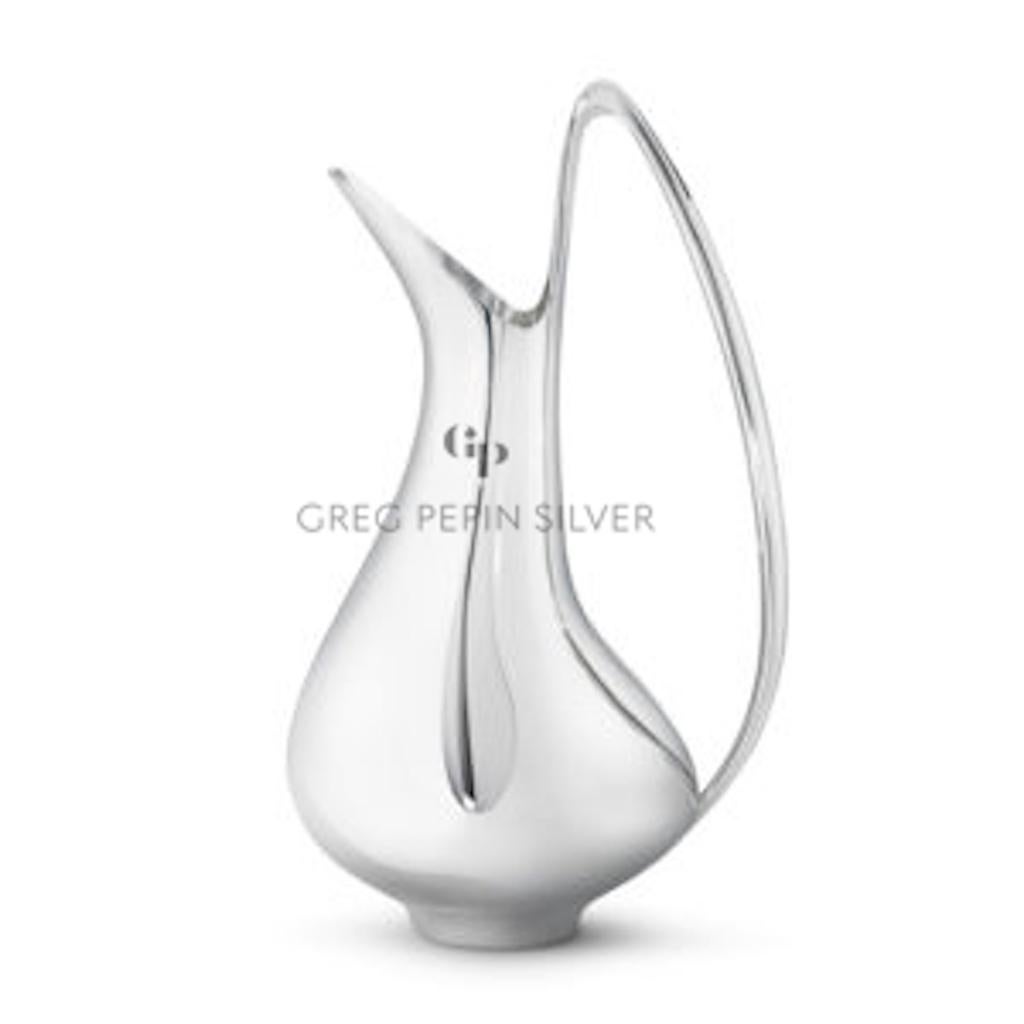 This is a very large sterling silver Georg Jensen pitcher, design #1052 by Henning Koppel from 1956, this design called the 