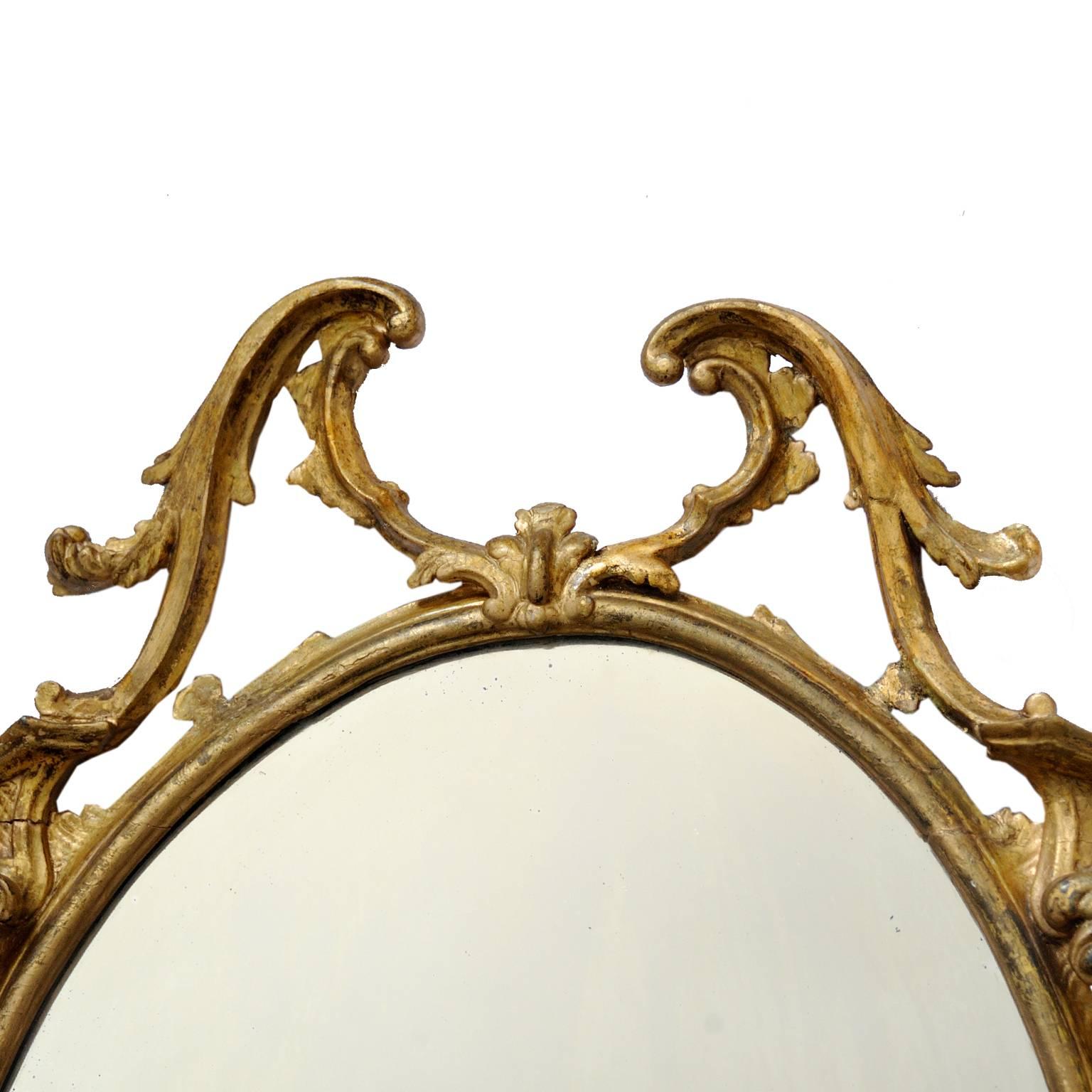 This is a large George II style gilt mirror in the Rococo taste. Carved wood and gesso with original mirror plate, circa 1860.