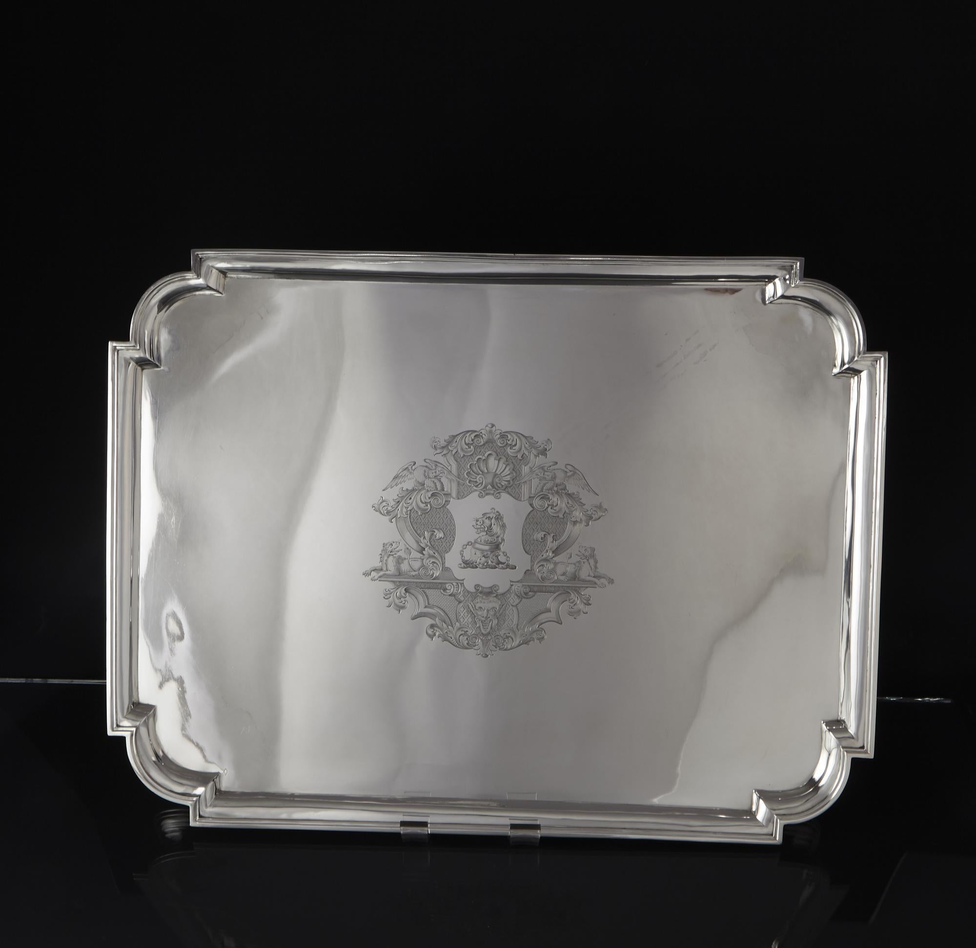 Large and wonderful quality antique silver tray or salver in the George II Videau style. It is oblong in form with shaped corners and mounted on four bracket feet. In the centre is a decorative cartouche, in the George II style, enclosing a crest of