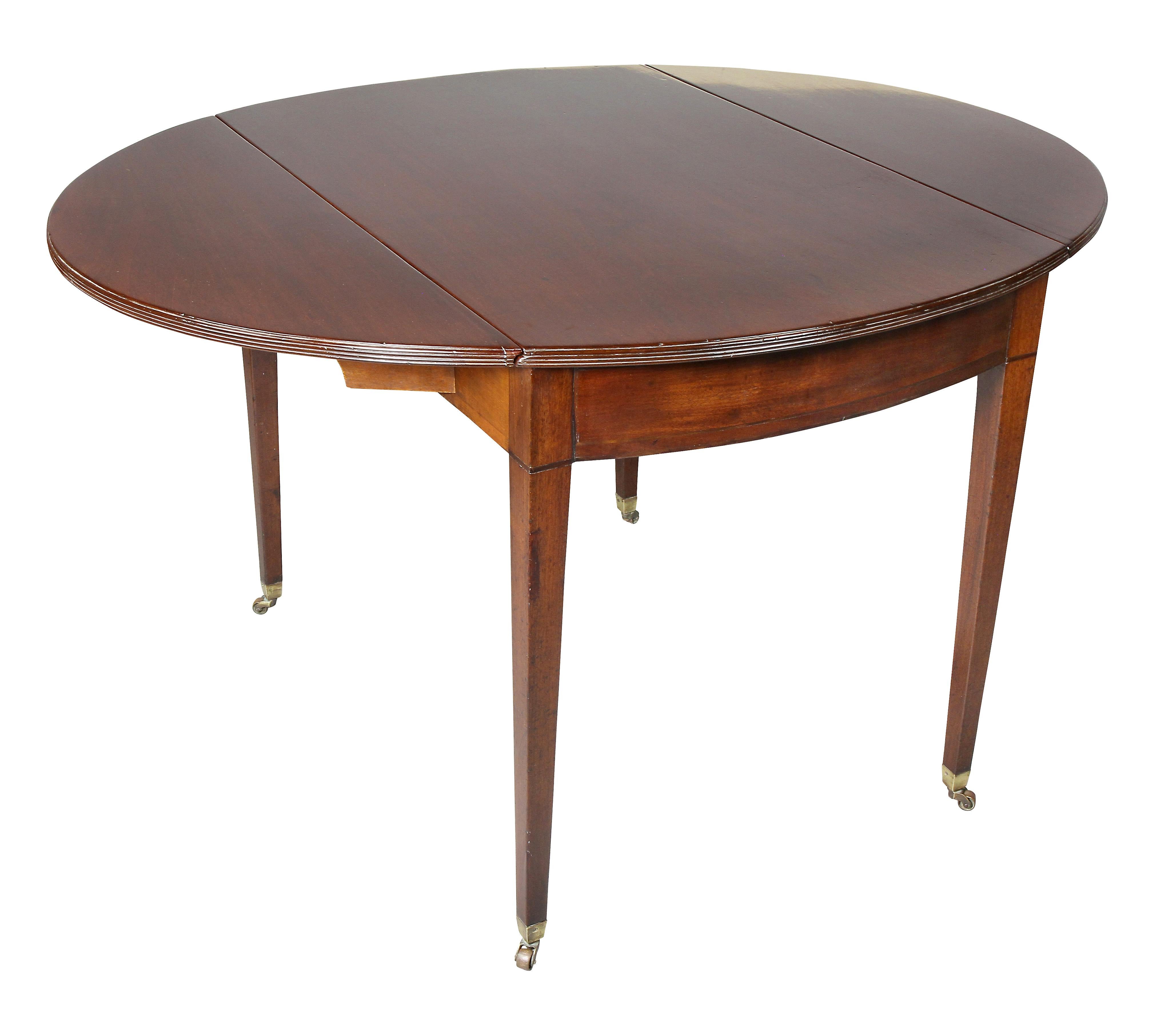 With rectangular top with demilune shaped drop leaves, raised on square tapered legs, casters. Volk Estate, Palm Beach.