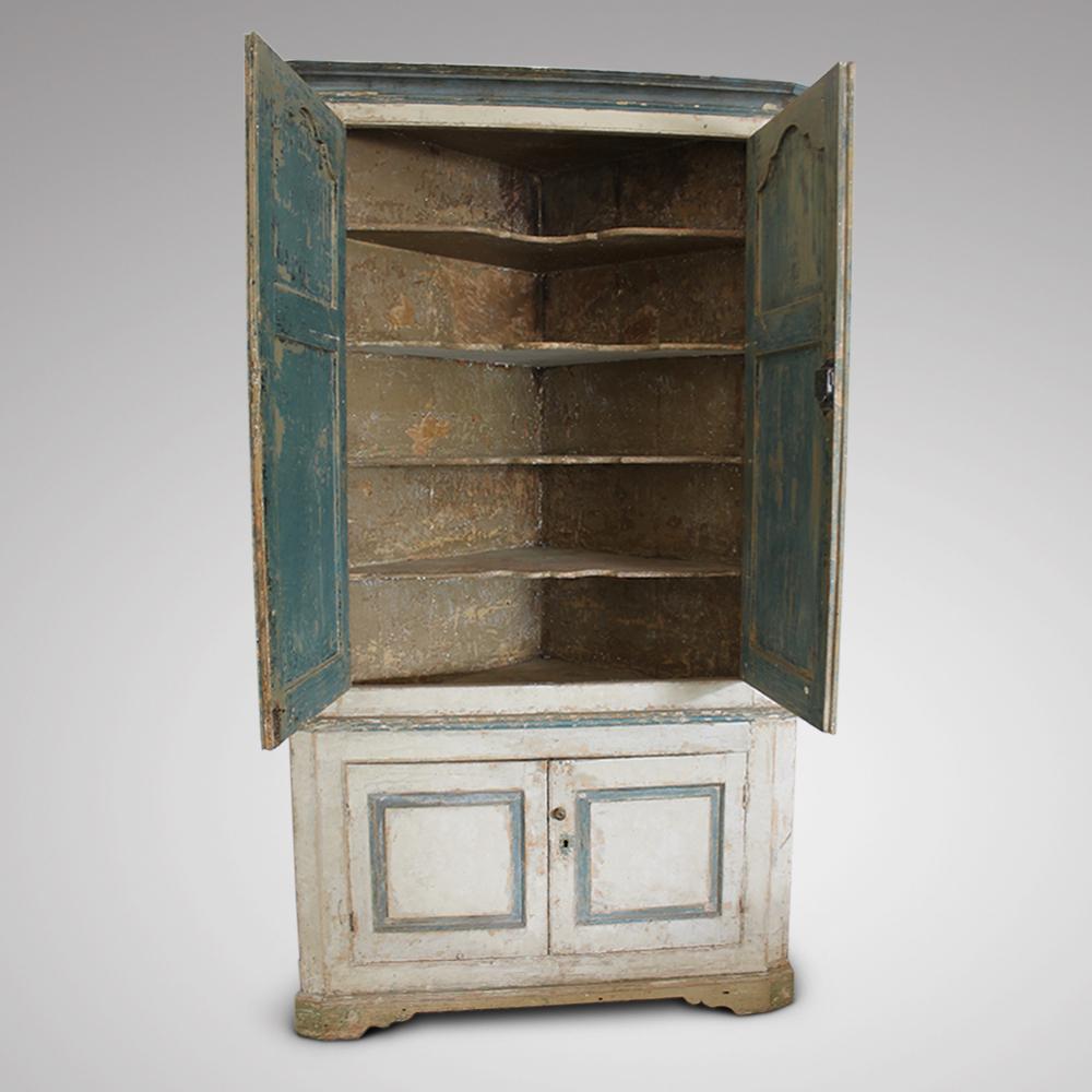 A truly wonderful, English, George III, floor standing pine corner cupboard. Dry scraped back creatively to early layers of off white and blue paint, with large shaped interior shelves and deep moulded panels. In very good condition, a couple of