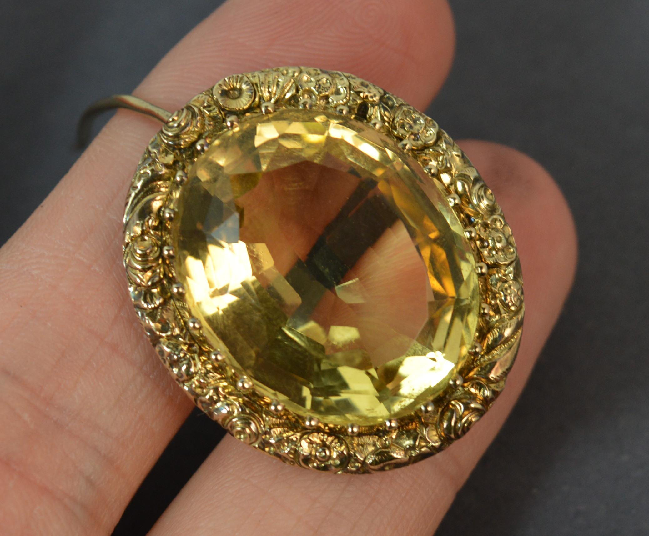 A stunning Georgian period brooch c1800. 
Solid 15 carat gold border. The front designed with deep floral relief pattern throughout.
The centre a large lemon drop expertly cut oval shaped citrine in full bezel setting. Stone approx 18.5mm x