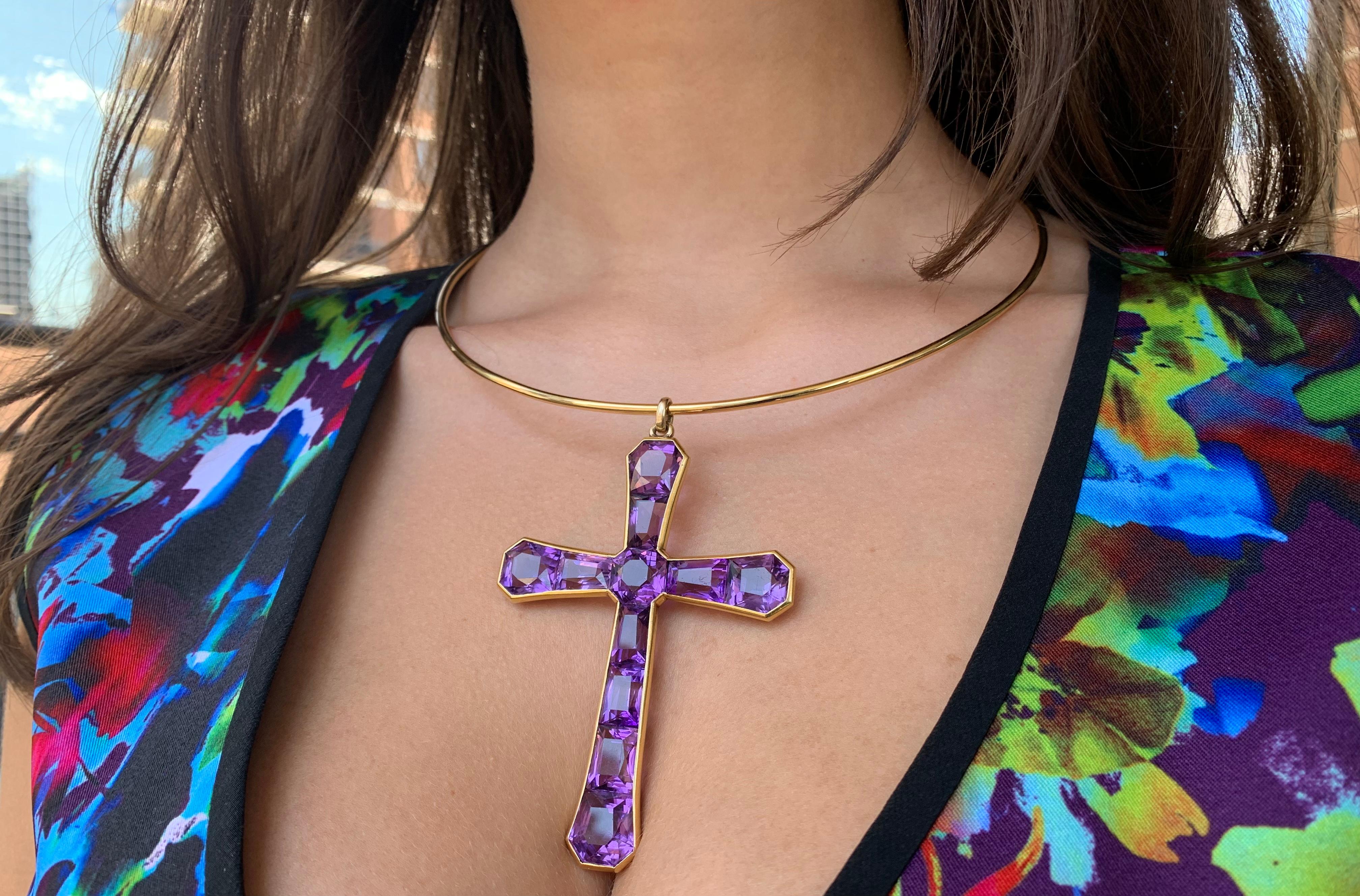 Elegant, large Georgian 18K gold invisibly set amethyst cross, featuring a central octagonal faceted amethyst surrounded by ten well matched faceted slightly flaring amethysts to form a beautifully shaped crucifix framed by an 18K yellow gold