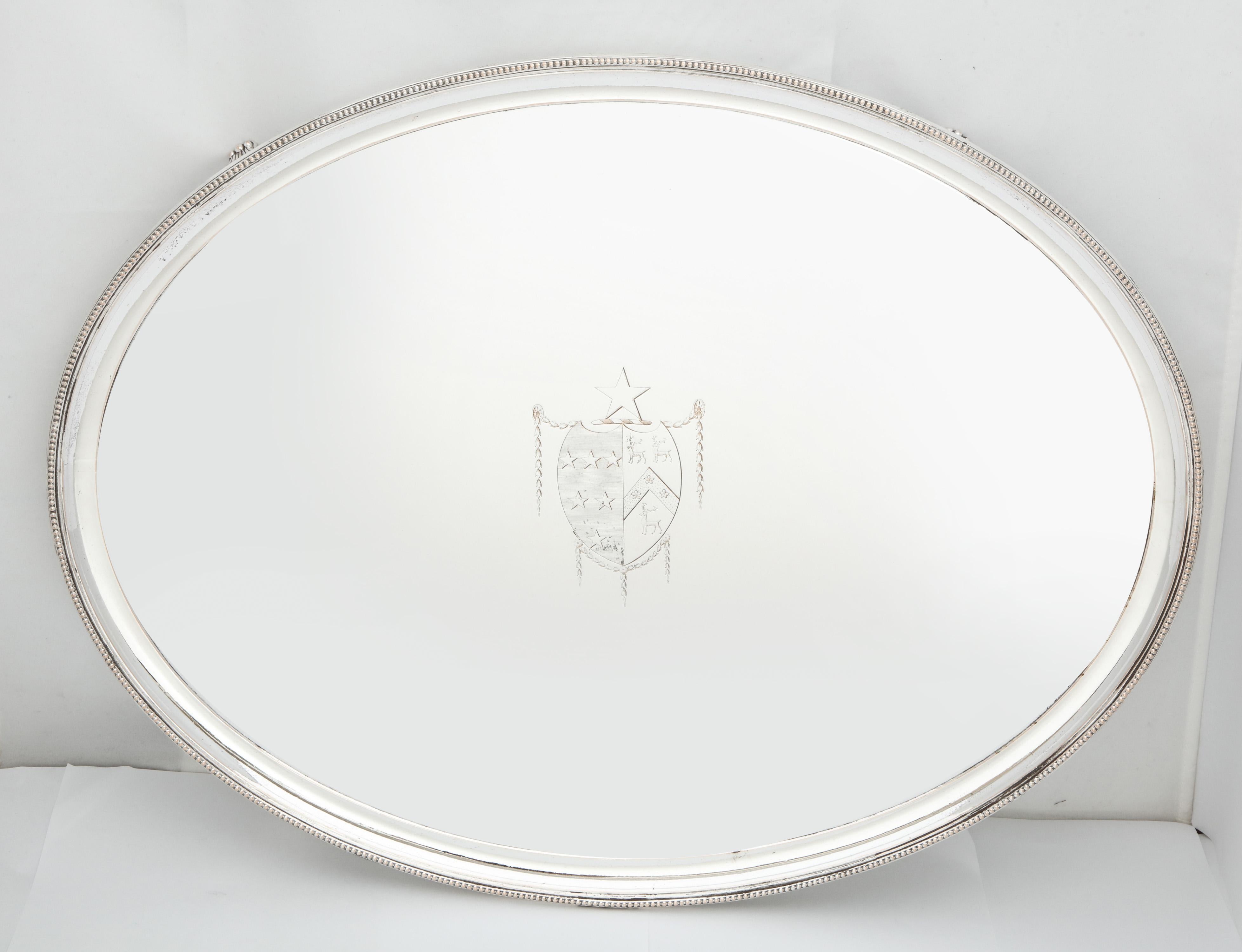 Large, Georgian (George III), Sheffield plated (Silver on copper), footed tray with central coat of arms, England, circa 1775. Border is beaded, has shell-form feet. Measures 20 inches wide x 15 1/2 inches deep x 1 3/4 inches high. Plating is in