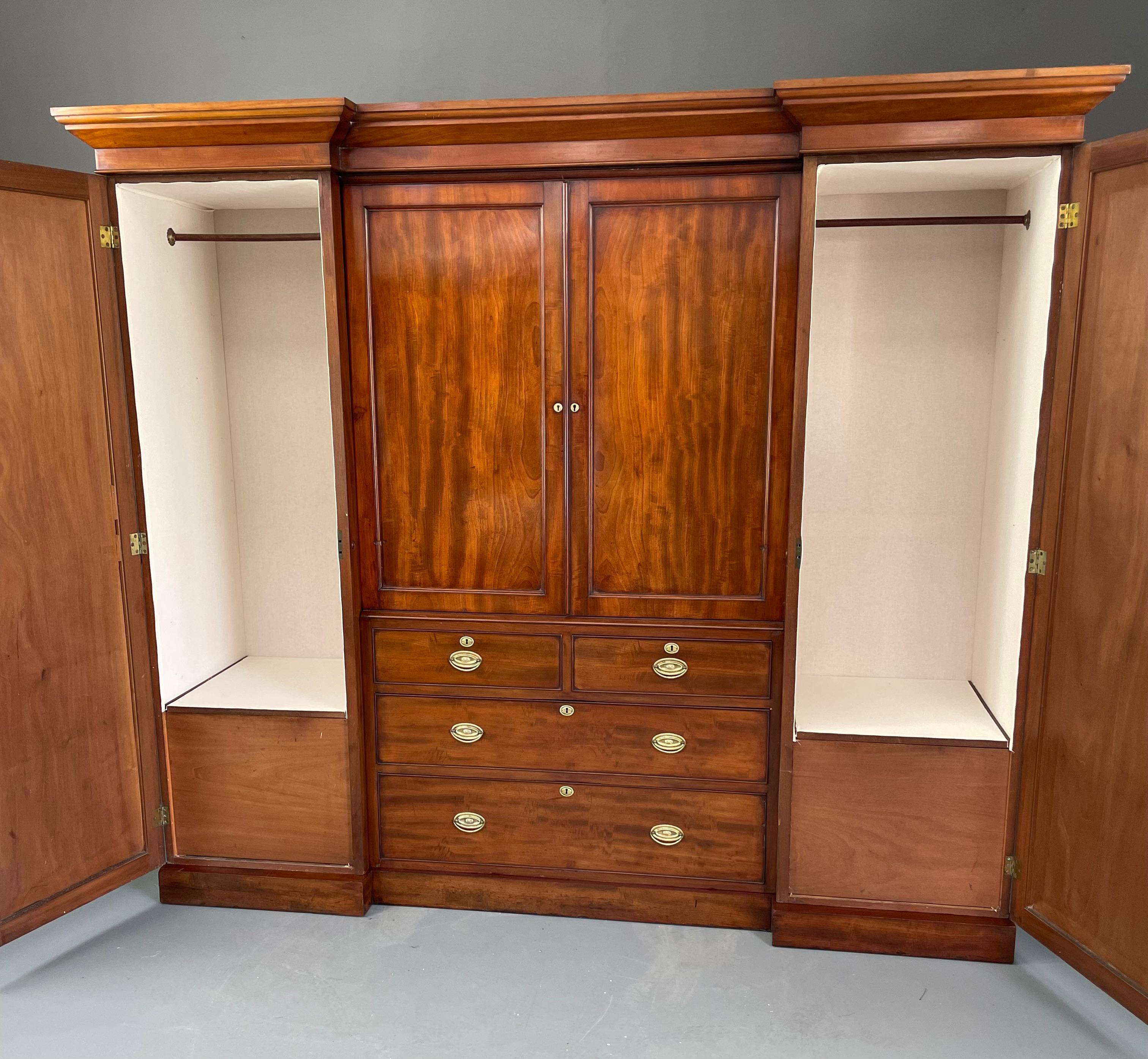 A fantastic Georgian mahogany breakfront wardrobe very practical for modern day use.
The wardrobe has two deep hanging sections that have been newly lined in a cotton fabric providing ample depth for modern hangers ,each section has a shoe and boot