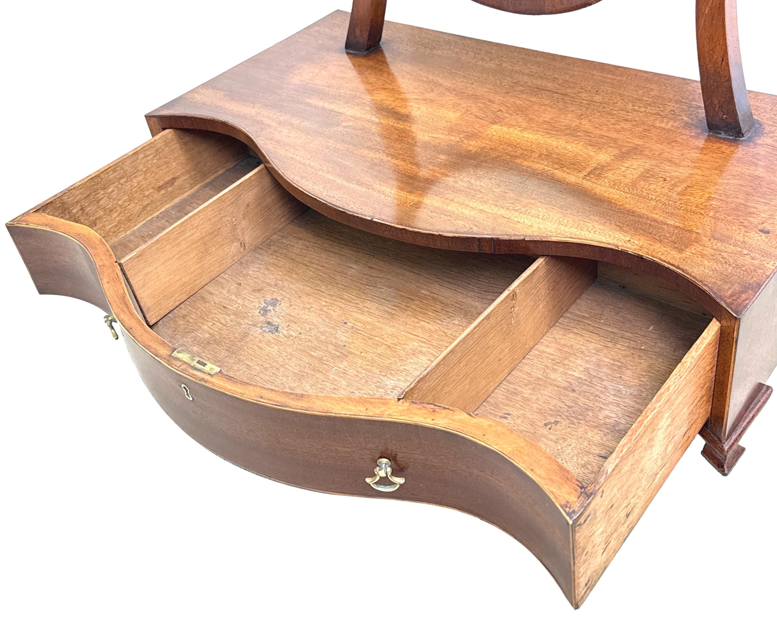 A Very Attractive Late 18th Century Mahogany Serpentine Shaped, Georgian Dressing Table Mirror, Of Unusually Large Proportions, Having Elegant Shield Shaped Plate, Over Shaped Base With One Long Frieze Drawer, Raised On Original Ogee Feet. 

Often