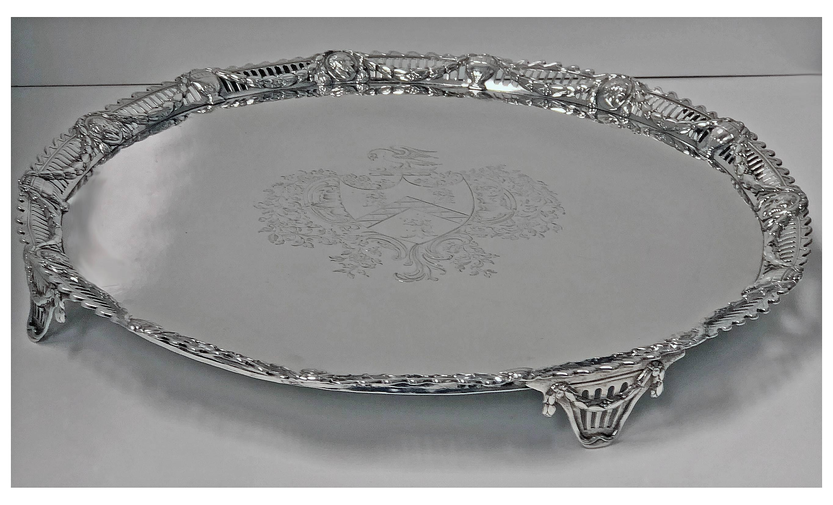 Fine large Georgian sterling silver salver, on four pierced festoon supports; cast hand pierced silver border decorated with medallions and festoon surround, John Carter, London 1774. Measures: Diameter 17 inches. Weight: 73 oz (2270 grams).