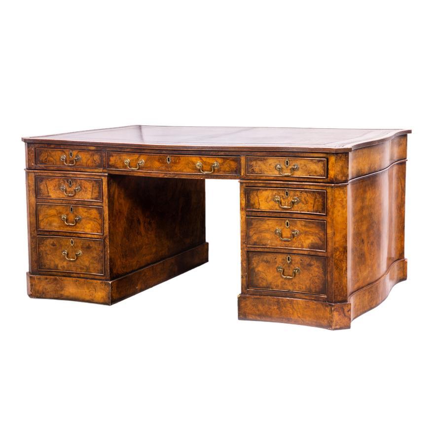 A fine quality English Georgian style partners desk of serpentine form, the claret colored gilt tooled leather top above 3 frieze drawers supported by 2 pedestals each with 3 graduated drawers, all supported on a plinth base. The reverse is