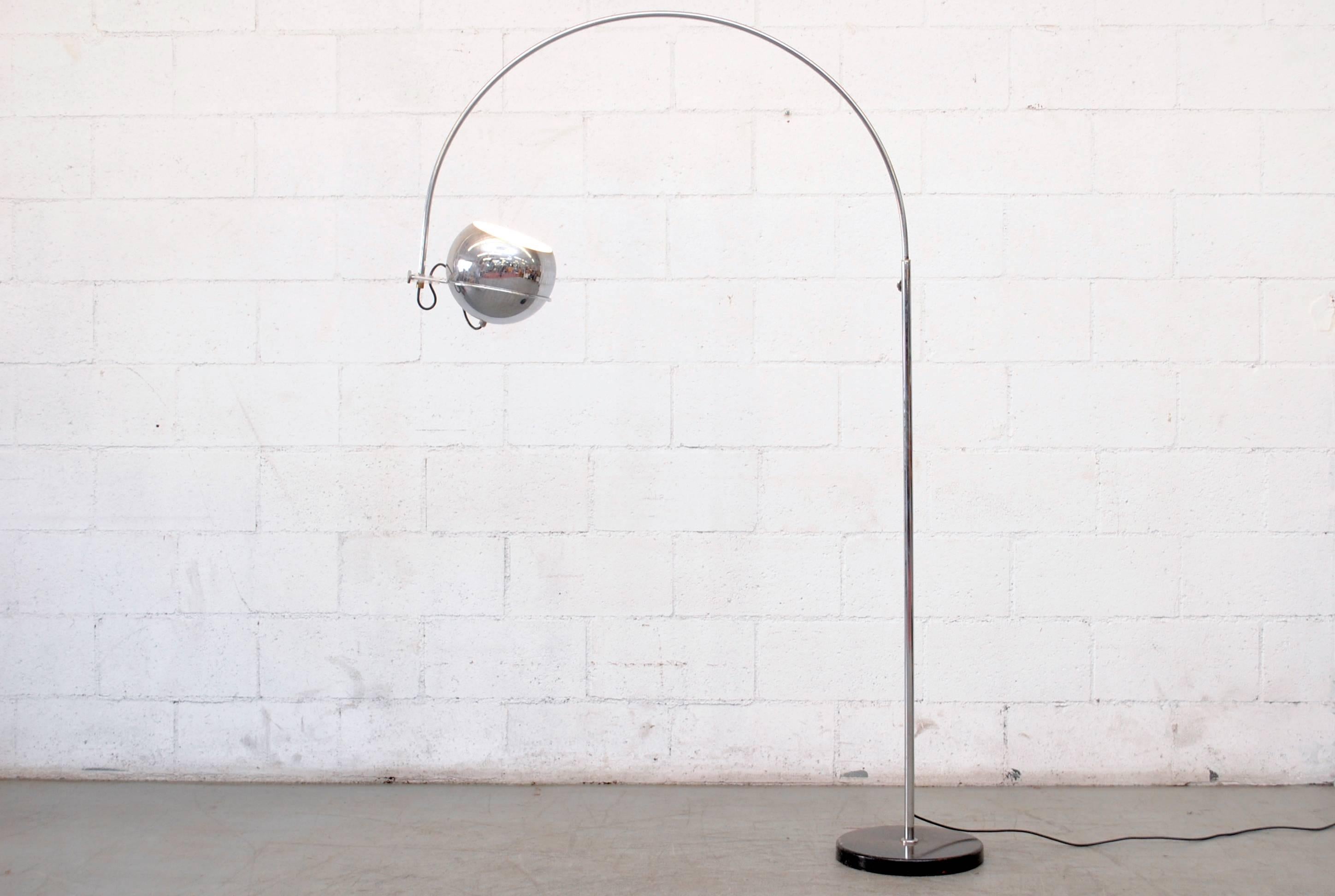 Chrome-plated standing floor lamp with single chrome globe. Adjustable height. Acrylic detail and black enameled metal weighted base. In original condition with some signs of wear, minimal enamel loss and some wear to the chrome.